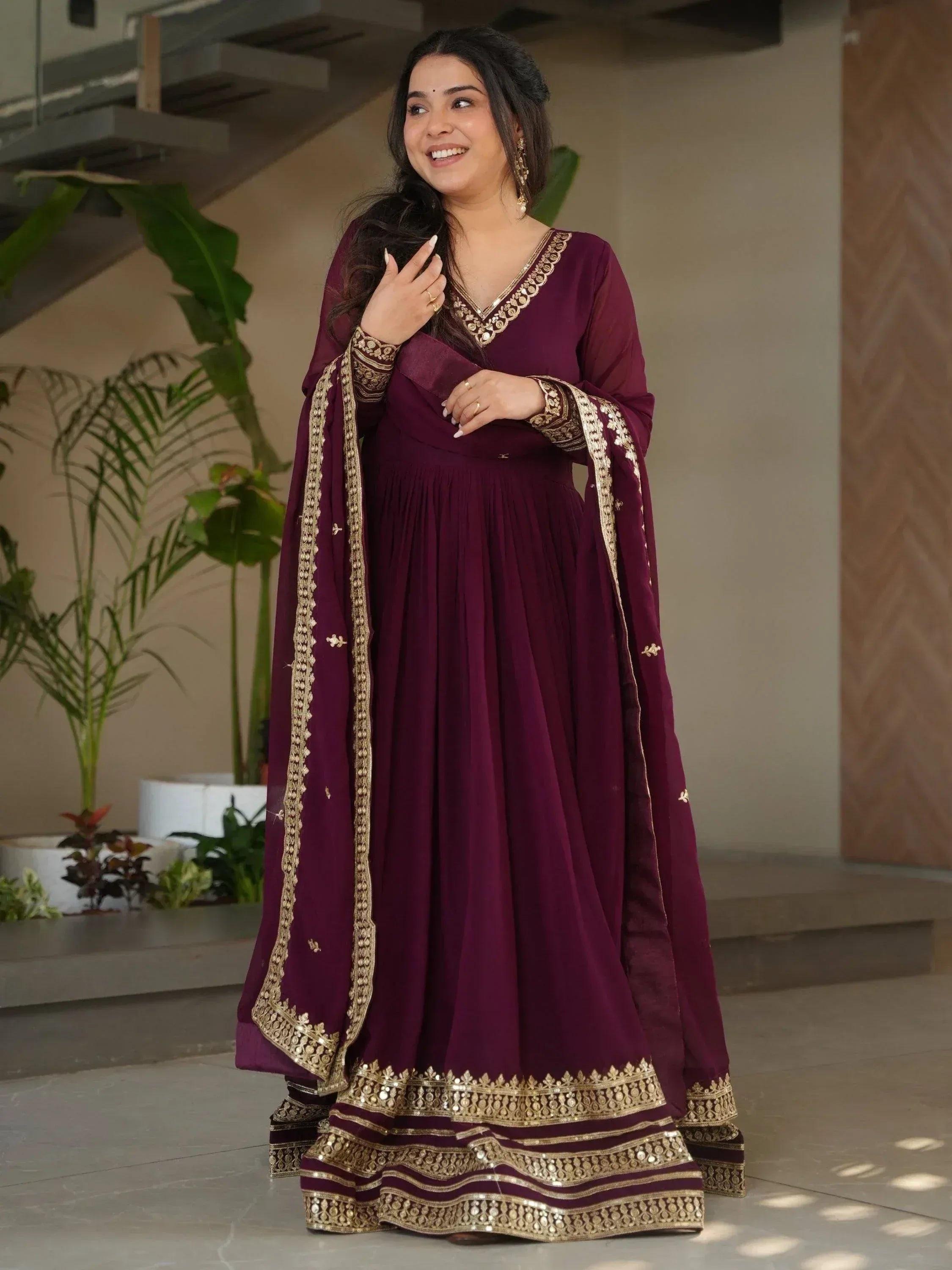 Elegant maroon ethnic gown with gold embroidery, perfect for Indian occasions and festive wear.