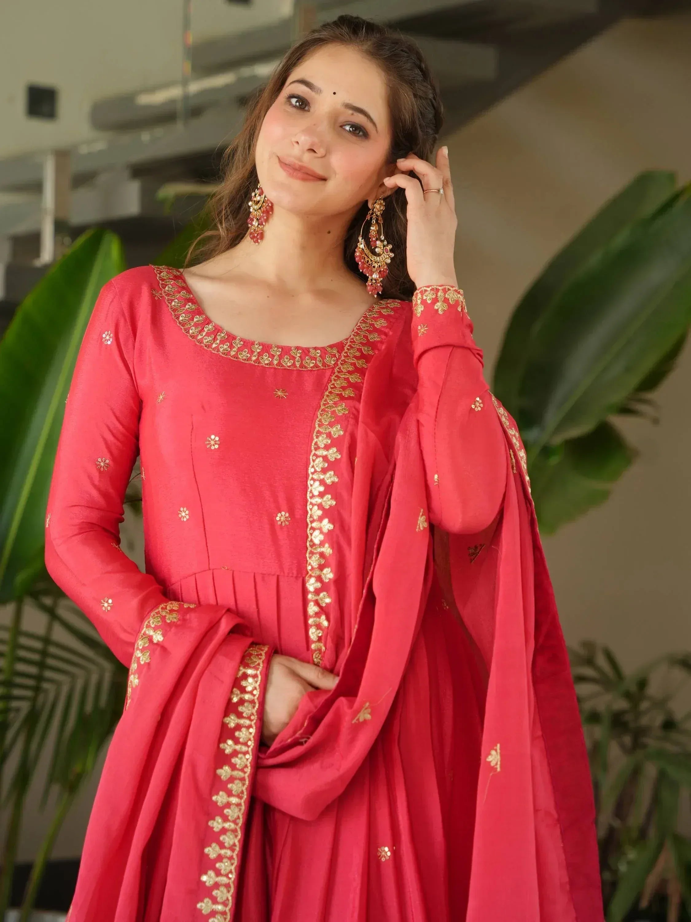 Woman in red ethnic anarkali with gold embroidery, perfect for Indian occasions and festive wear.
