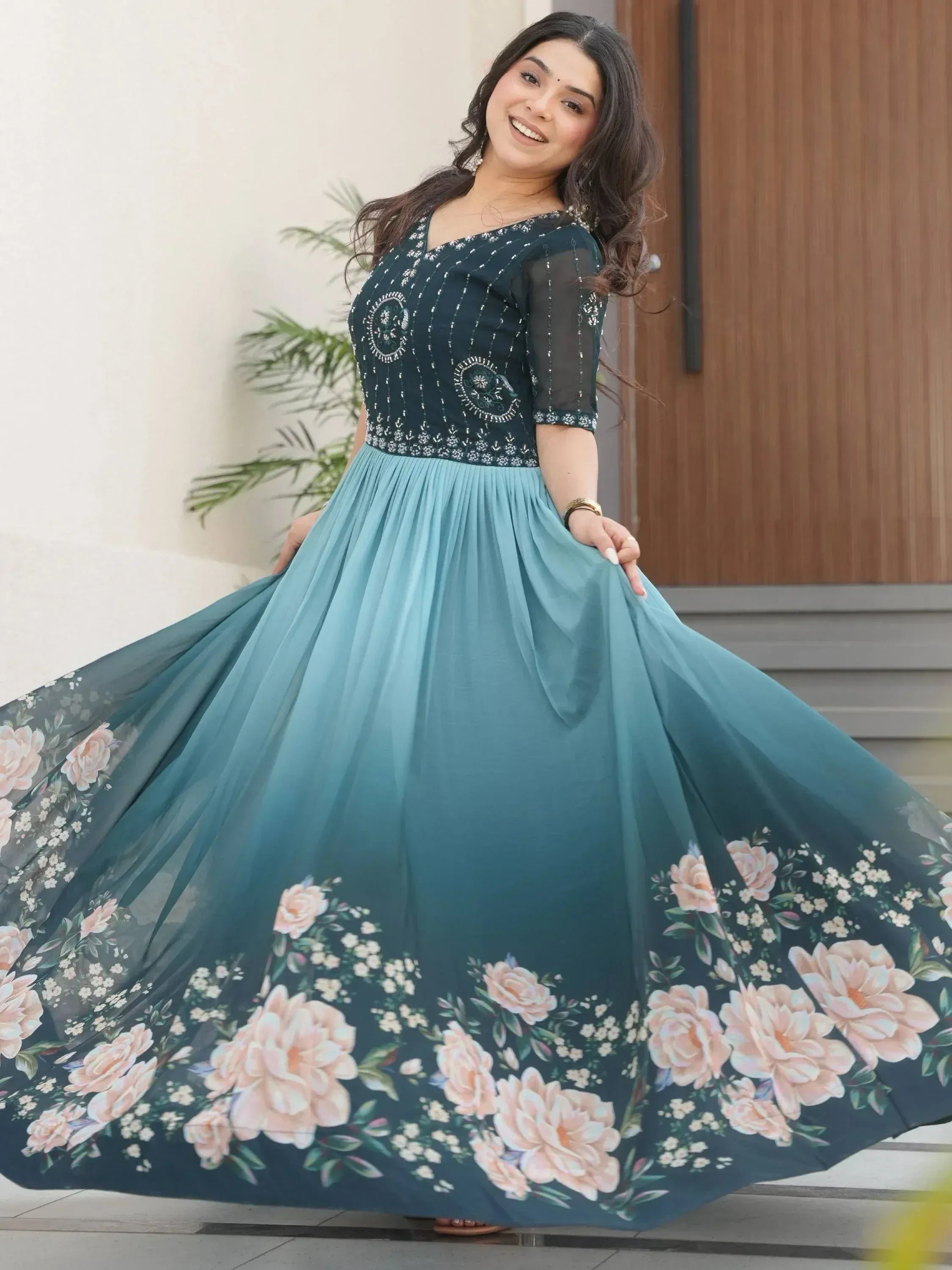 Woman in elegant teal ethnic gown with floral print and embroidery, perfect for Indian occasions