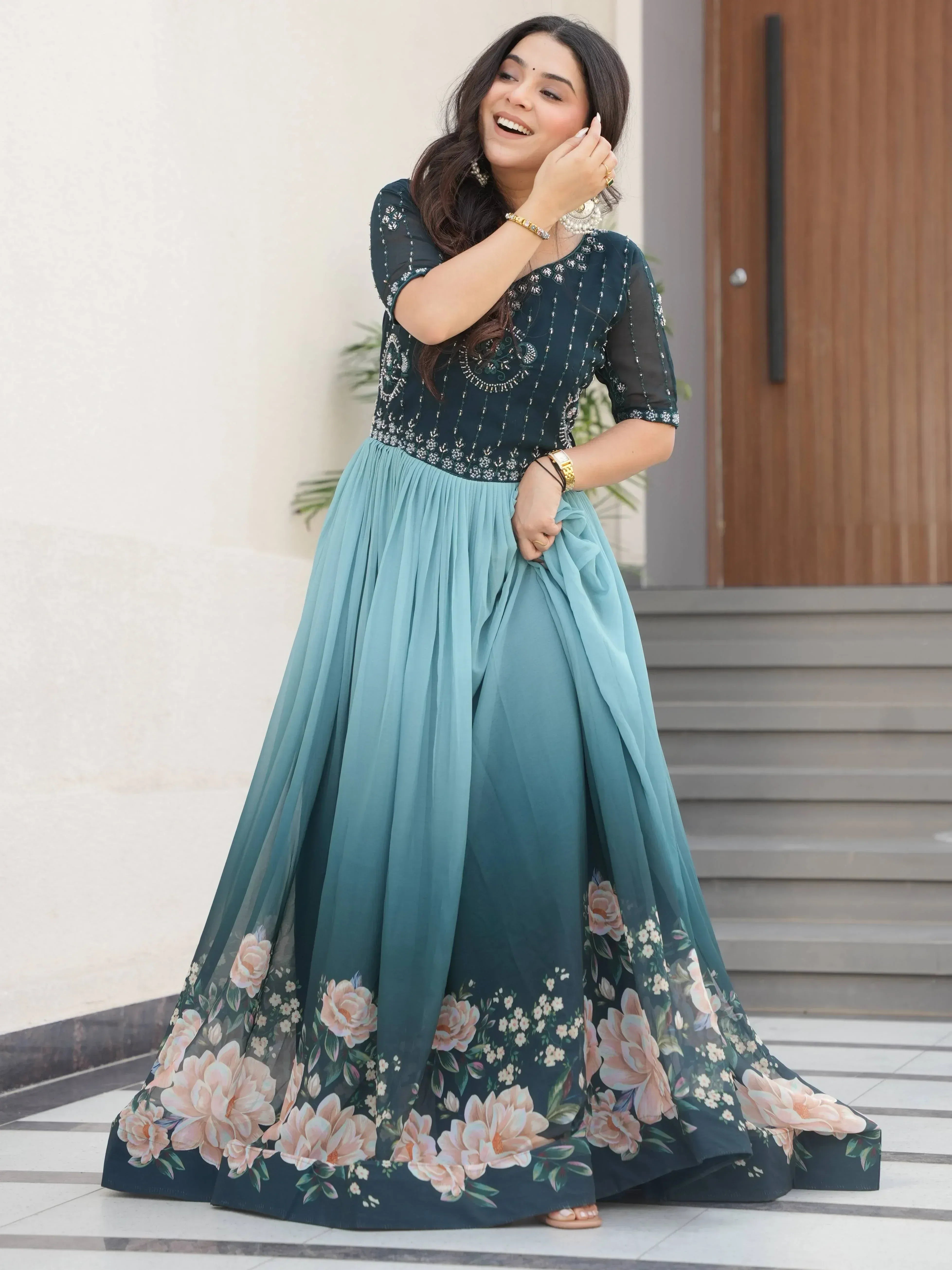 Woman in teal floral ethnic gown with embroidered top, perfect for Indian occasions
