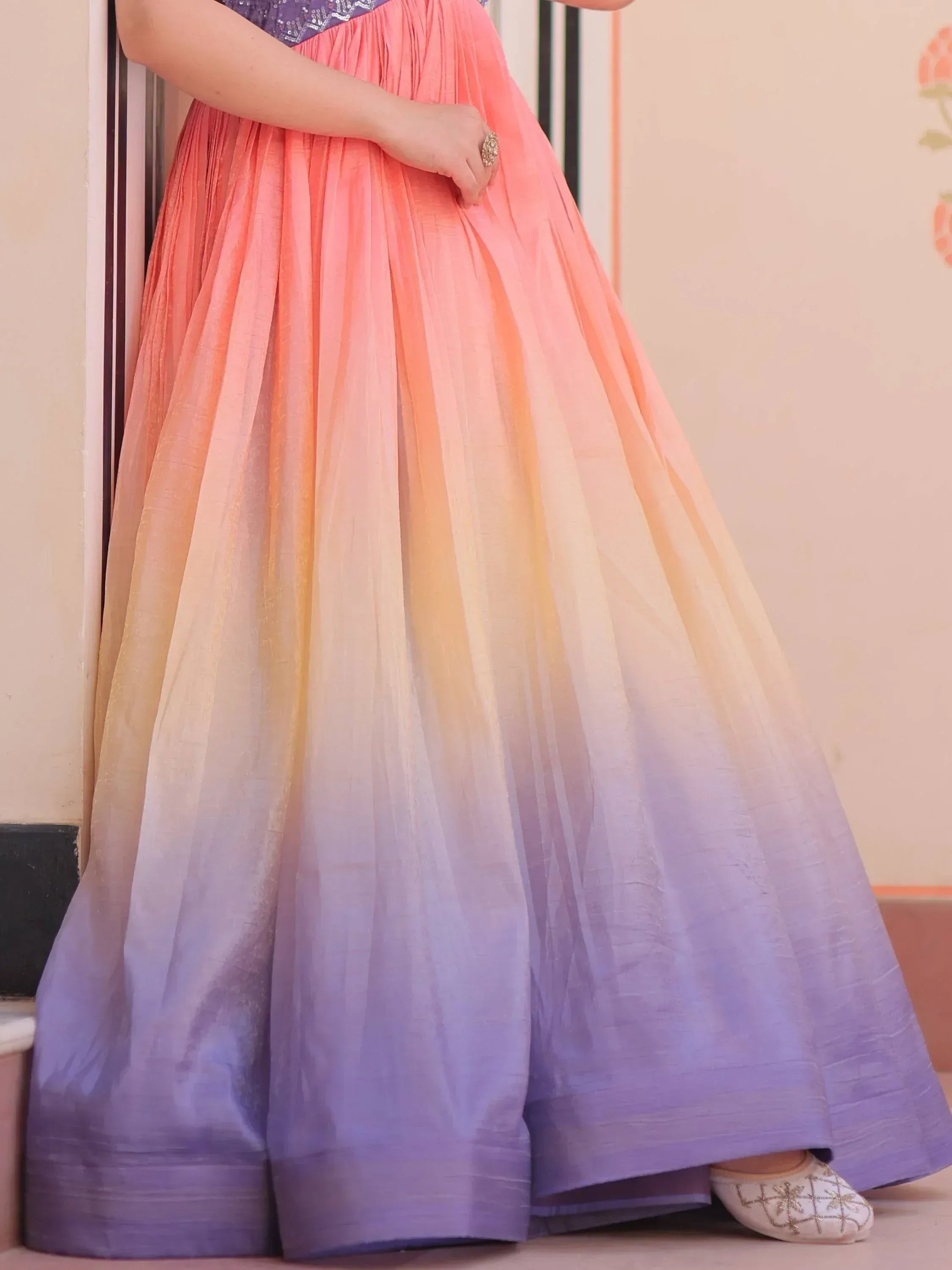 Ombre ethnic gown with pleated skirt in coral to lavender gradient, paired with embellished flats