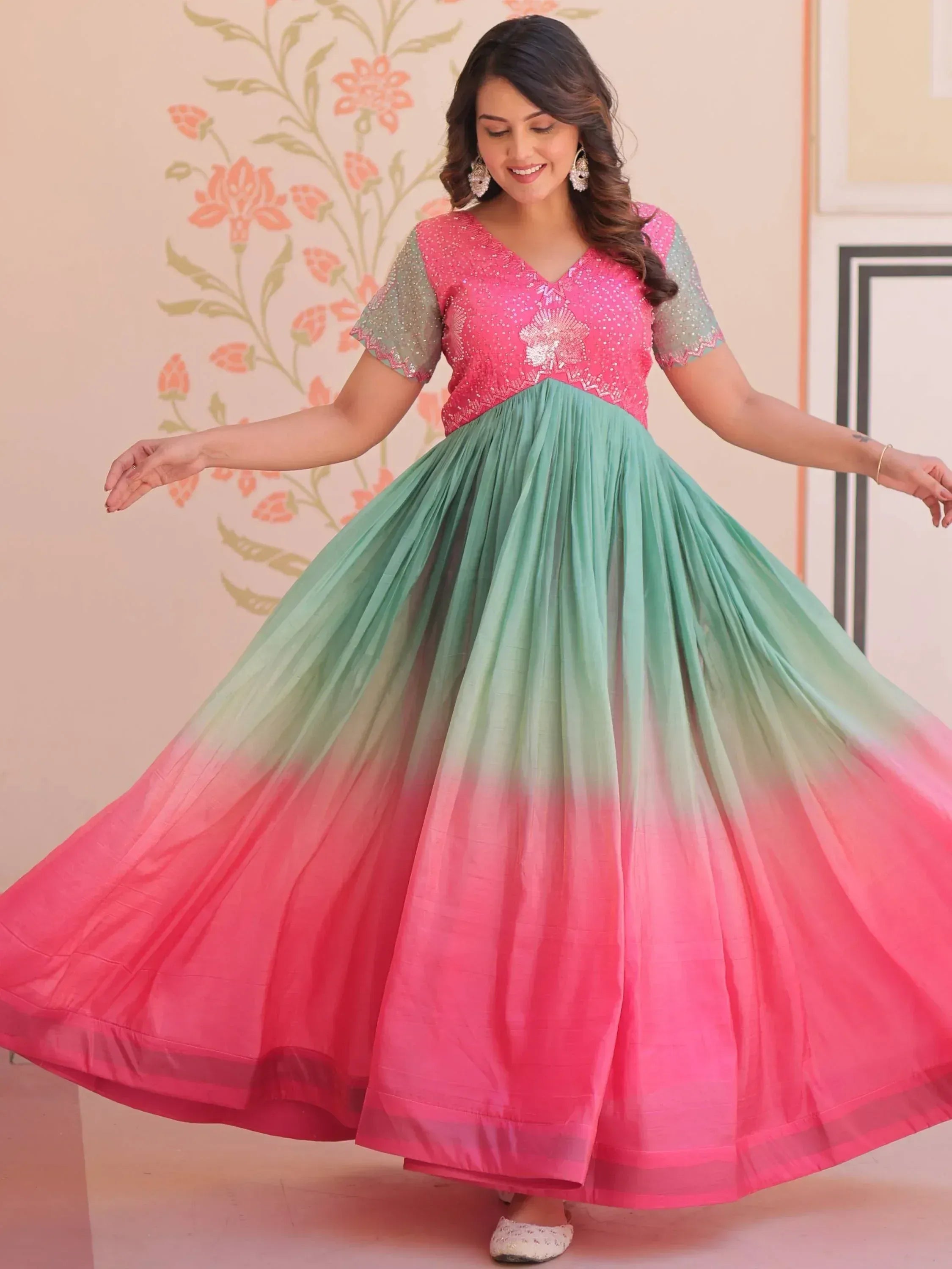 Woman in pink and mint green ombre ethnic gown with sequin embroidery, twirling gracefully