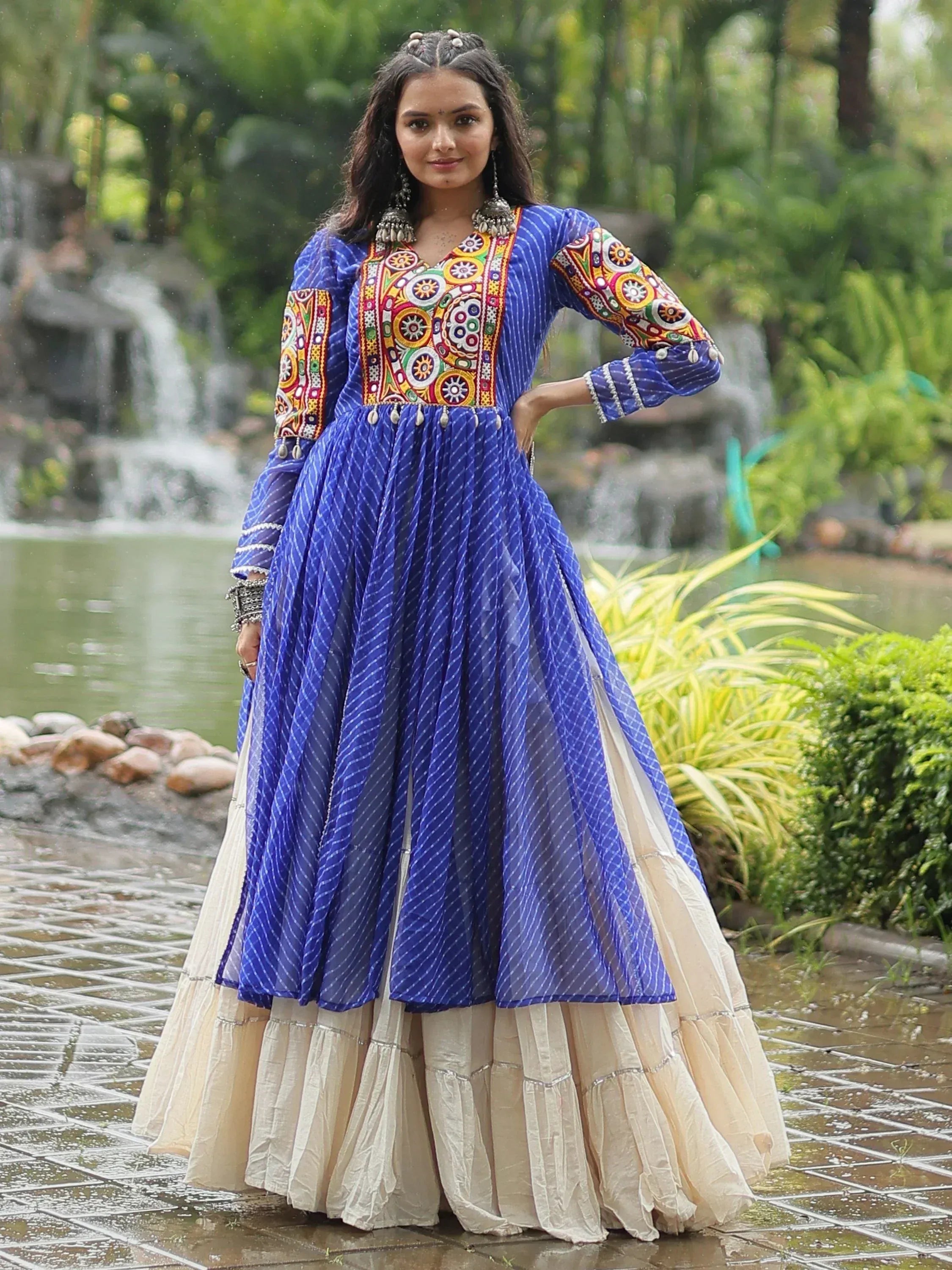 Blue embroidered anarkali with colorful mirror work, paired with cream layered skirt, perfect for Indian ethnic wear.