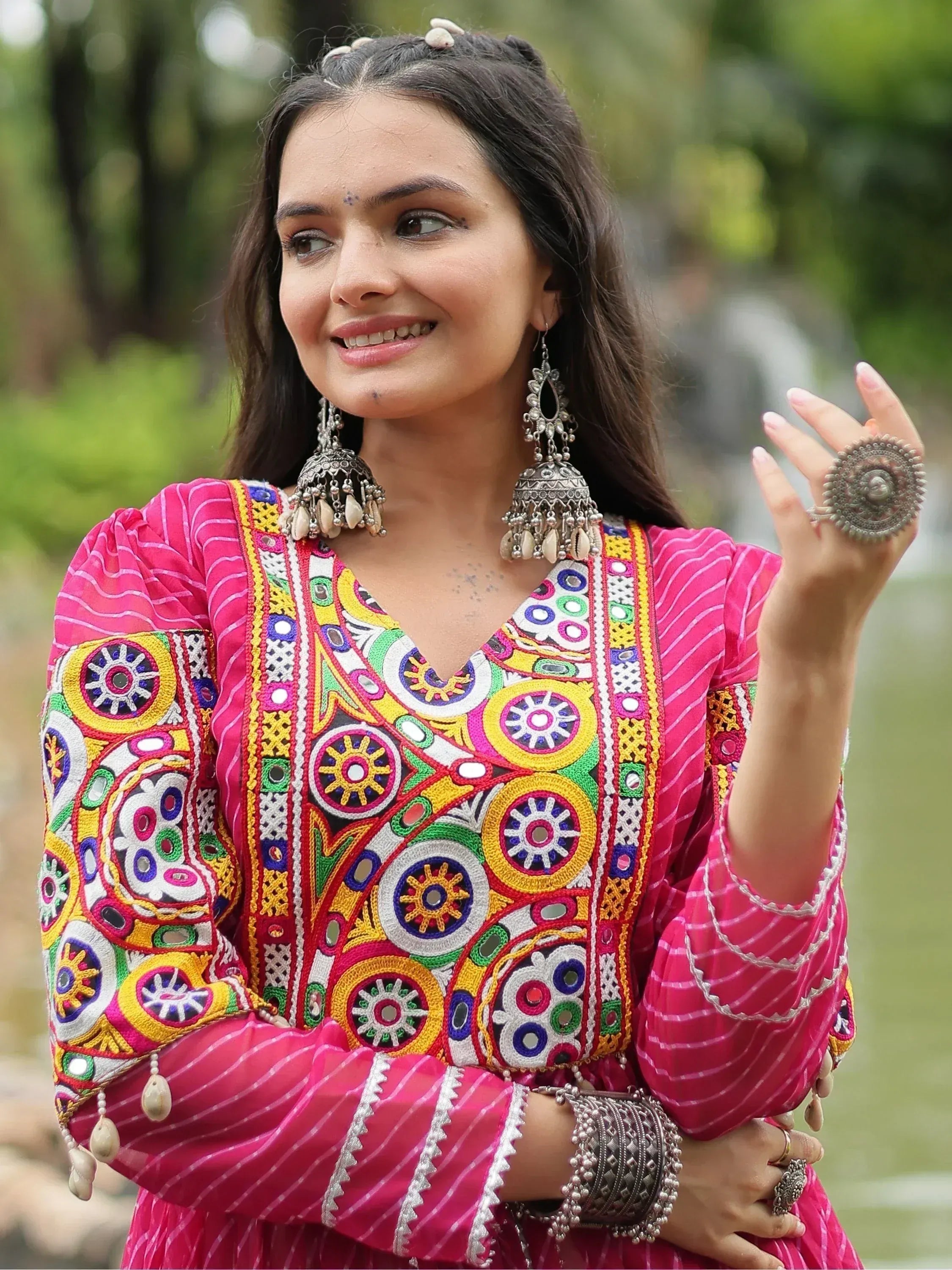 Vibrant pink ethnic kurta with colorful mirror embroidery, traditional jewelry, and festive design for Indian wear