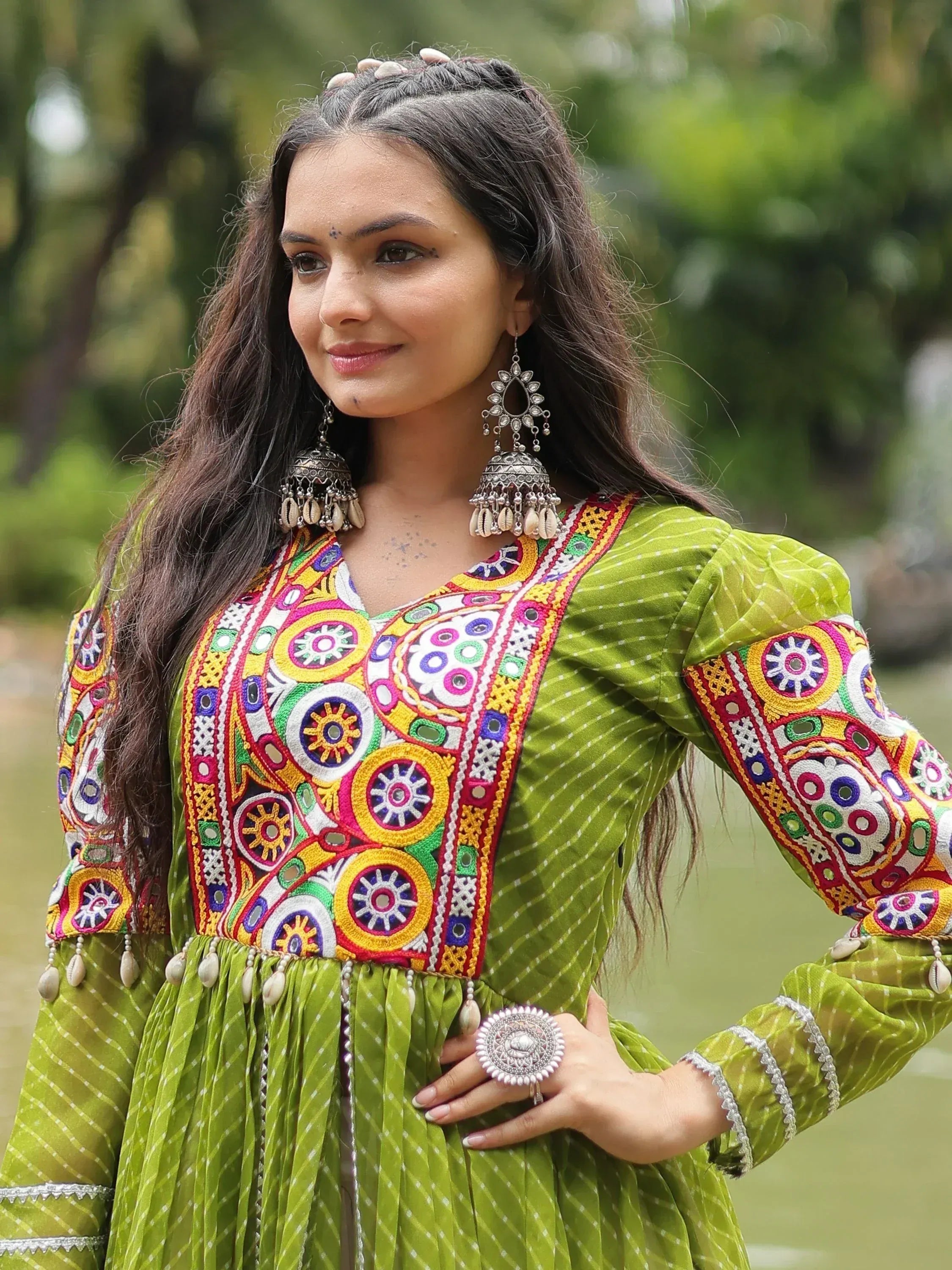 Green ethnic gown with colorful mirror embroidery and traditional jewelry for Indian wear