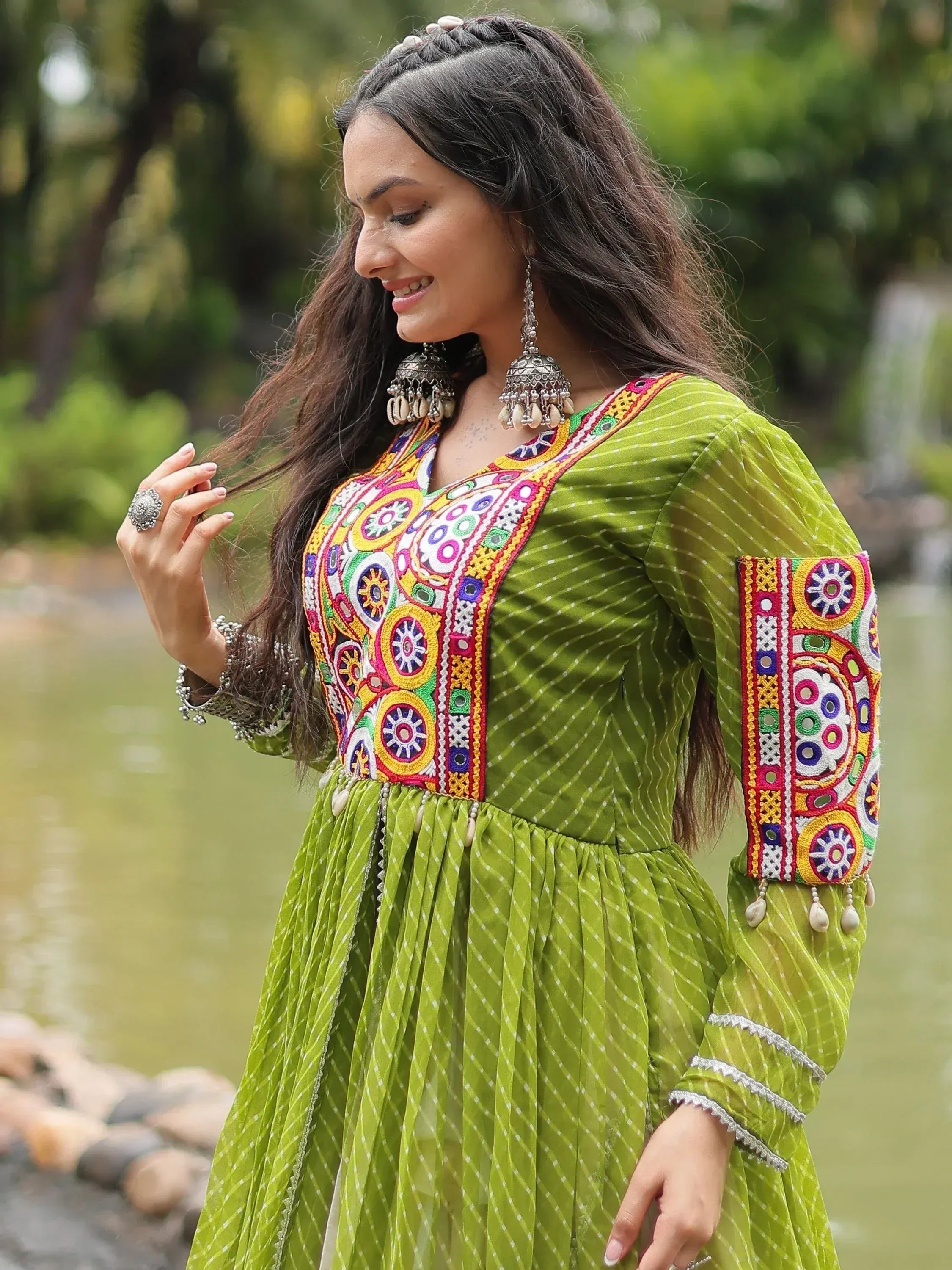 Green embroidered ethnic gown with colorful mirror work and jhumka earrings