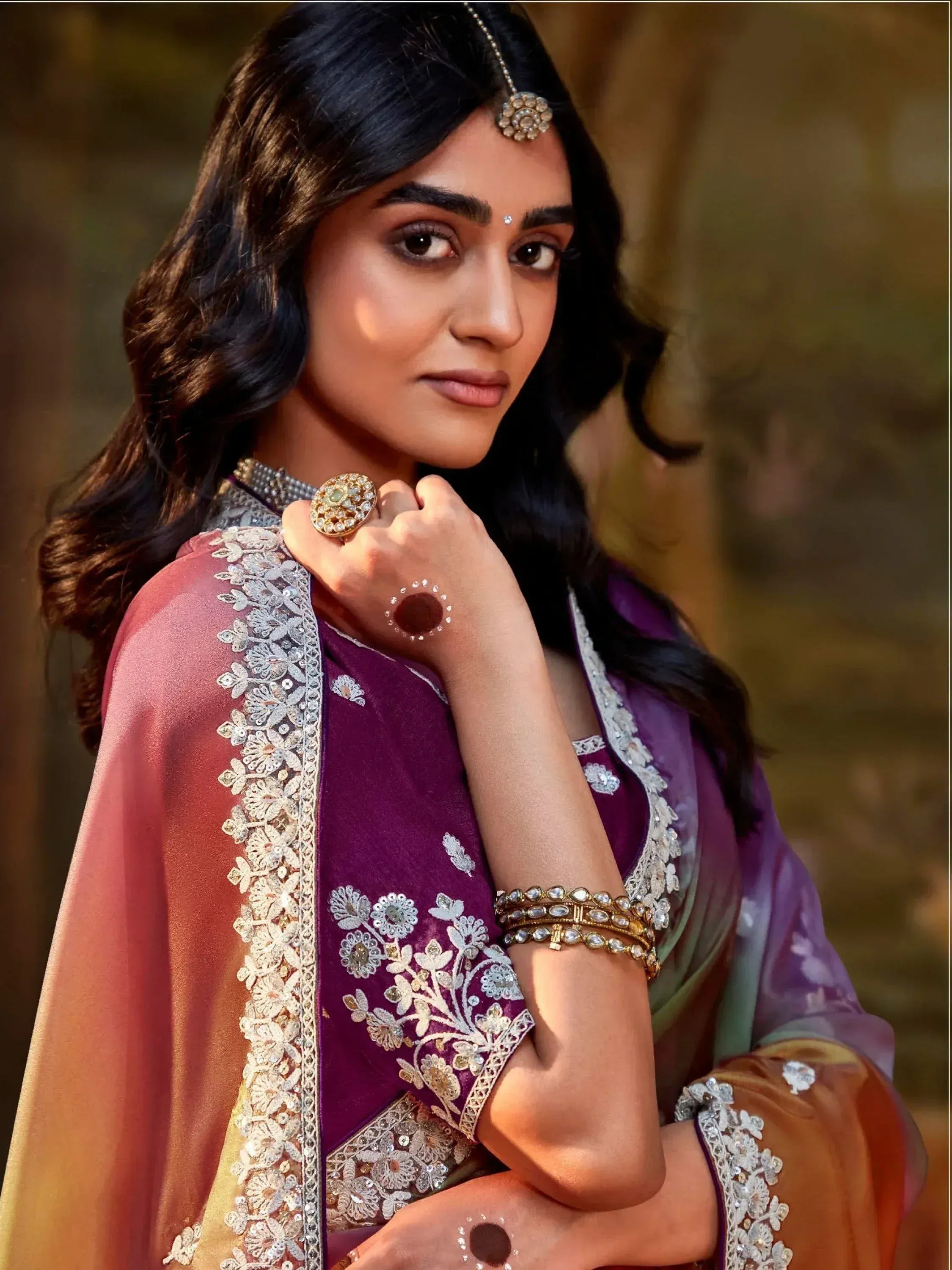 Woman in purple embroidered Indian ethnic wear with floral detailing and traditional jewelry