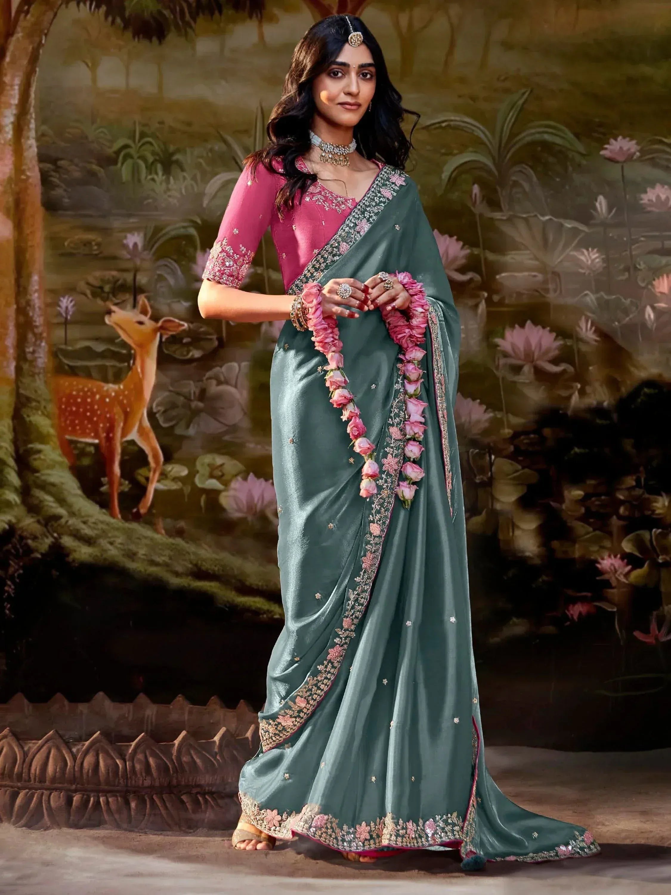 Elegant teal saree with pink floral border, paired with embroidered pink blouse, perfect for Indian ethnic wear.