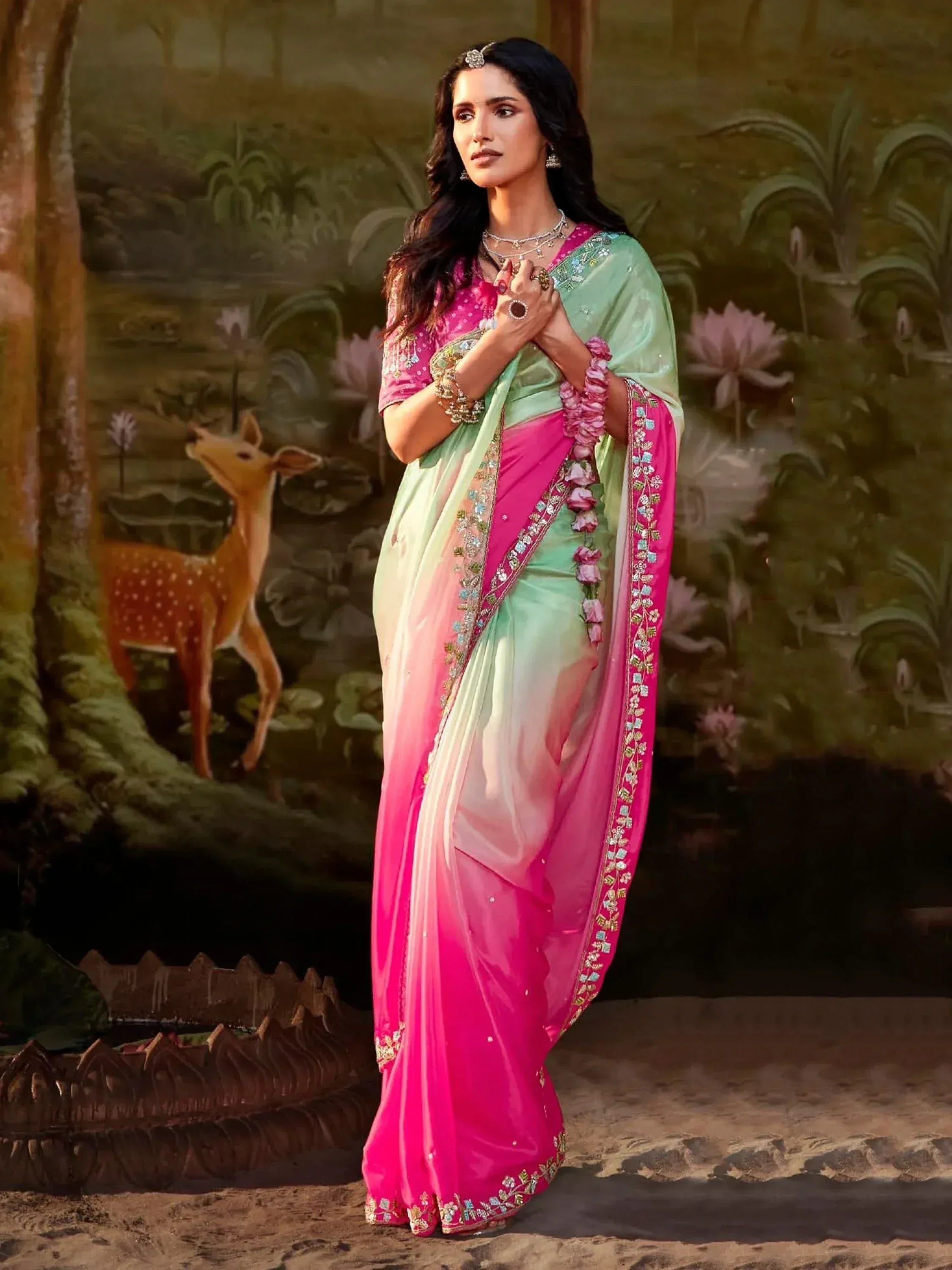 Woman in pink and mint green embroidered saree with floral border, styled for Indian ethnic wear