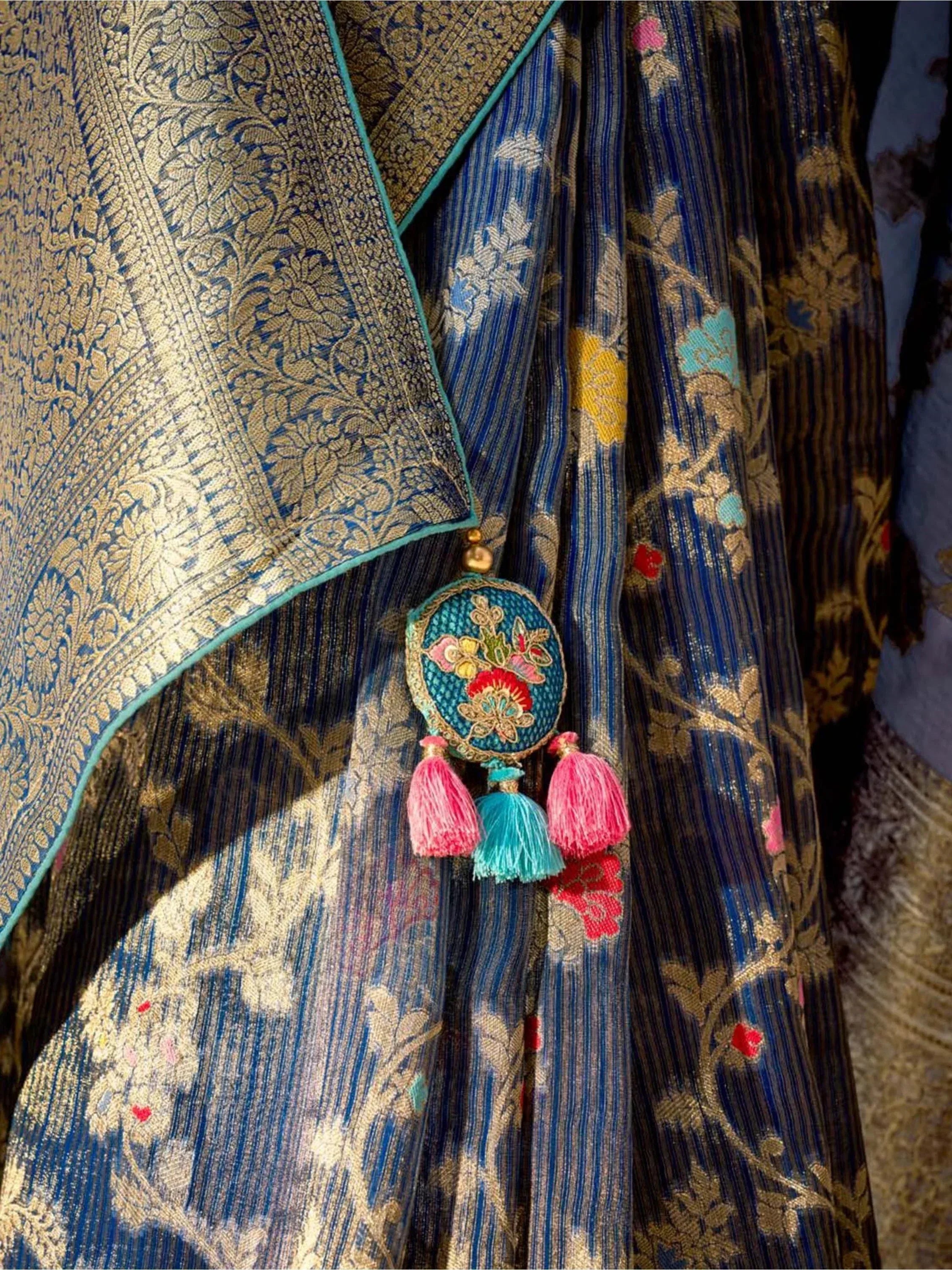 Blue and gold embroidered ethnic saree with floral tassels, perfect for Indian festive wear