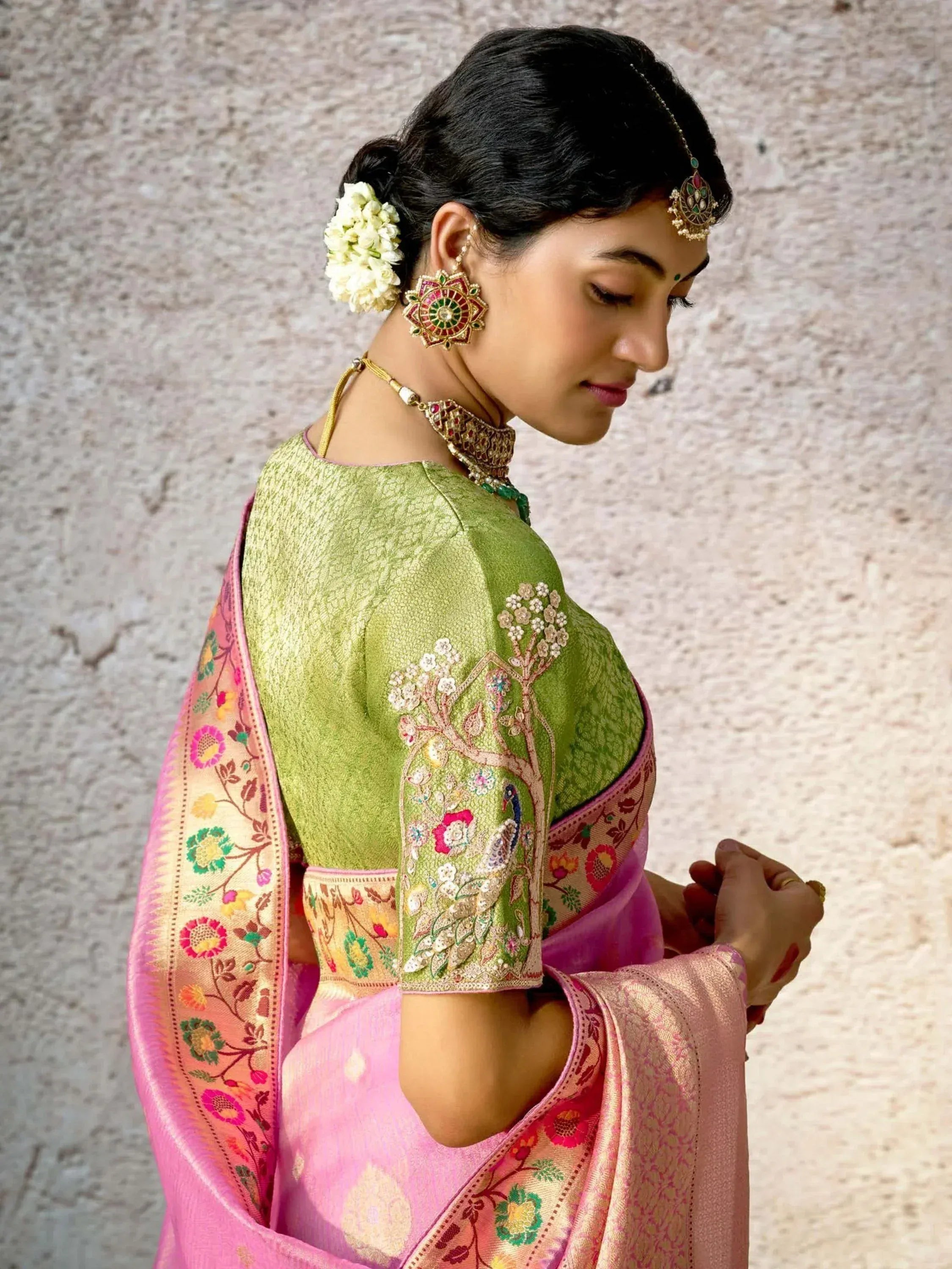 Woman in green embroidered blouse with pink floral saree, traditional Indian ethnic wear
