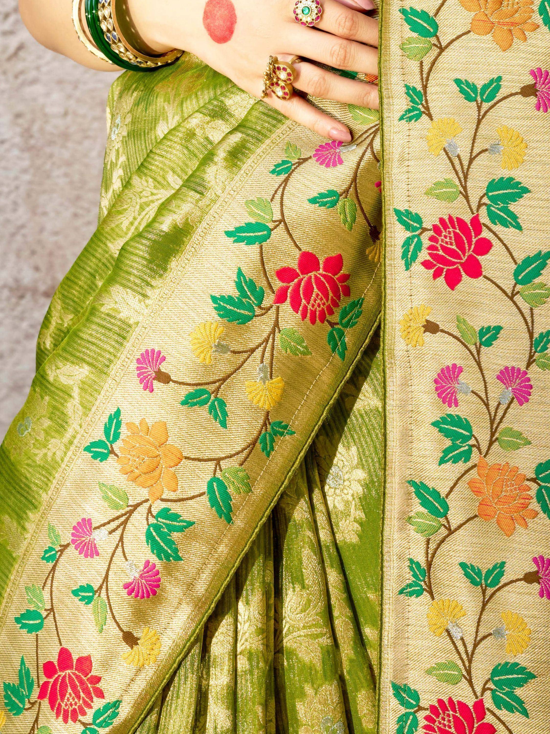 Green floral embroidered saree with colorful blooms and traditional Indian jewelry
