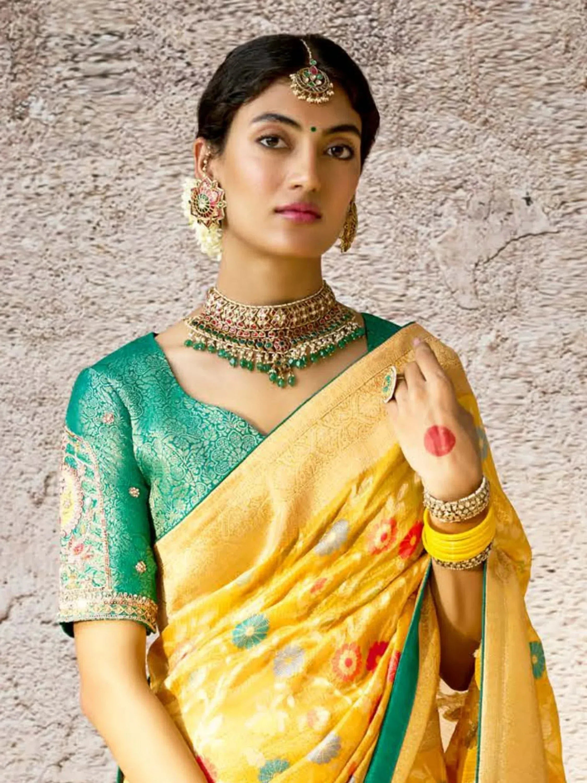 Woman in yellow floral saree with green blouse, traditional Indian ethnic wear, adorned with jewelry