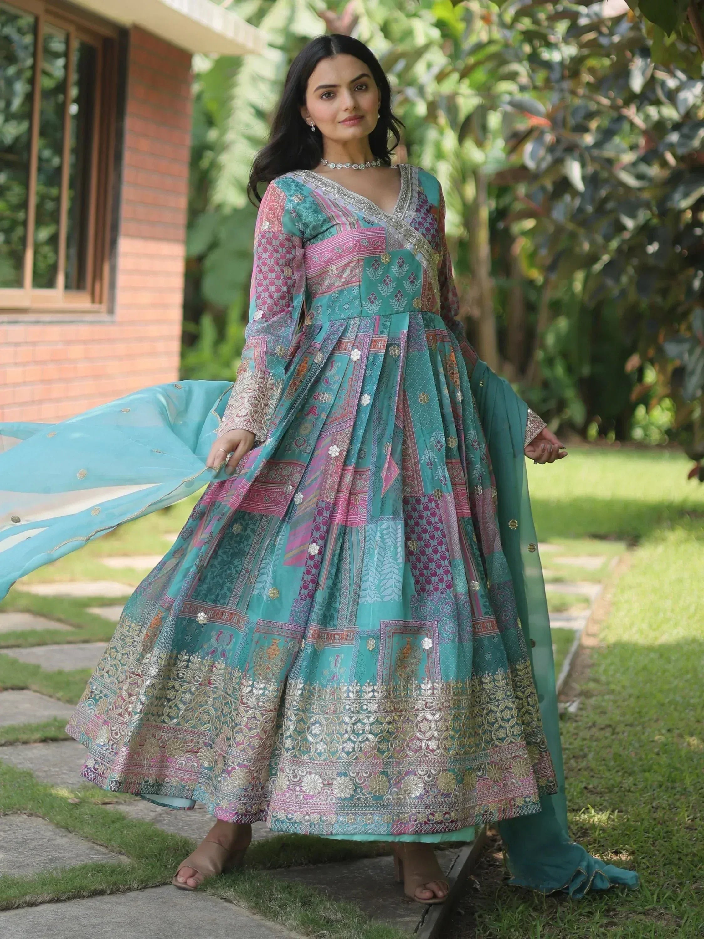 Woman in teal and pink printed ethnic anarkali gown with dupatta, perfect for Indian occasions