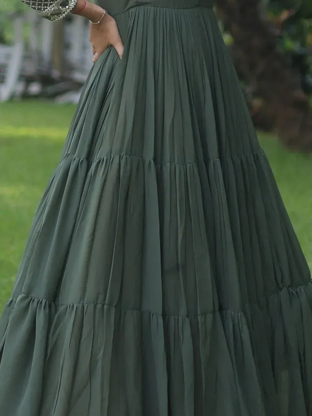 Olive green tiered pleated ethnic gown with embellished sleeve, perfect for festive occasions.