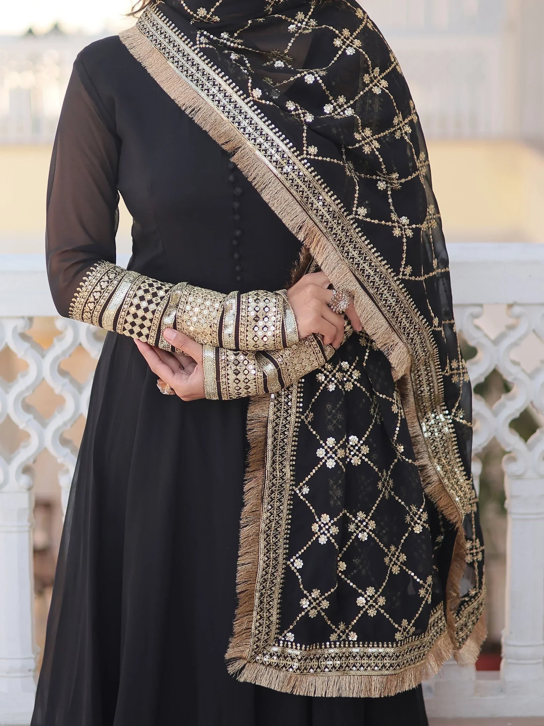 Black ethnic gown with sheer sleeves and gold embroidered dupatta, traditional Indian jewelry