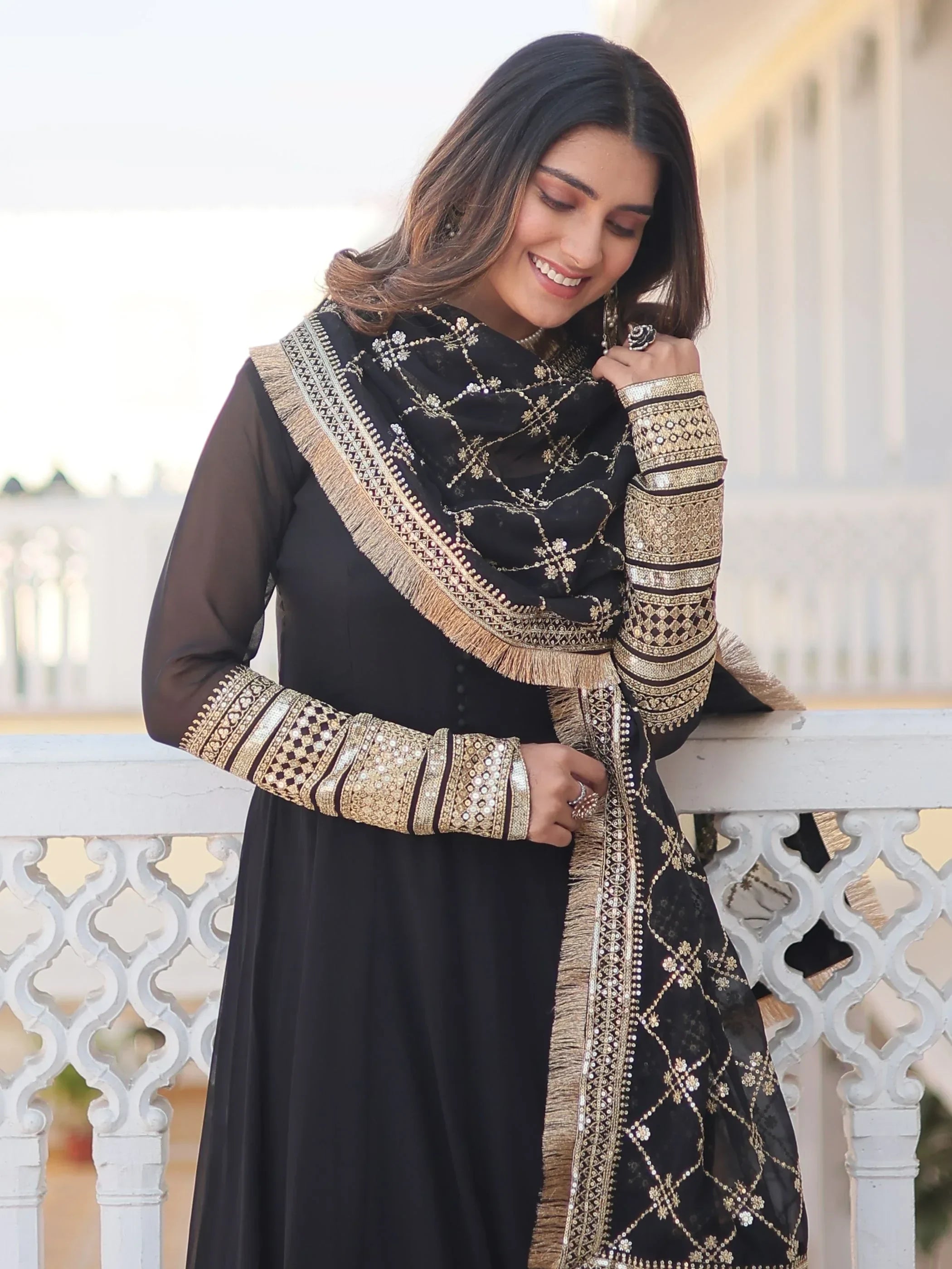 Woman wearing black and gold embroidered ethnic salwar kameez with dupatta