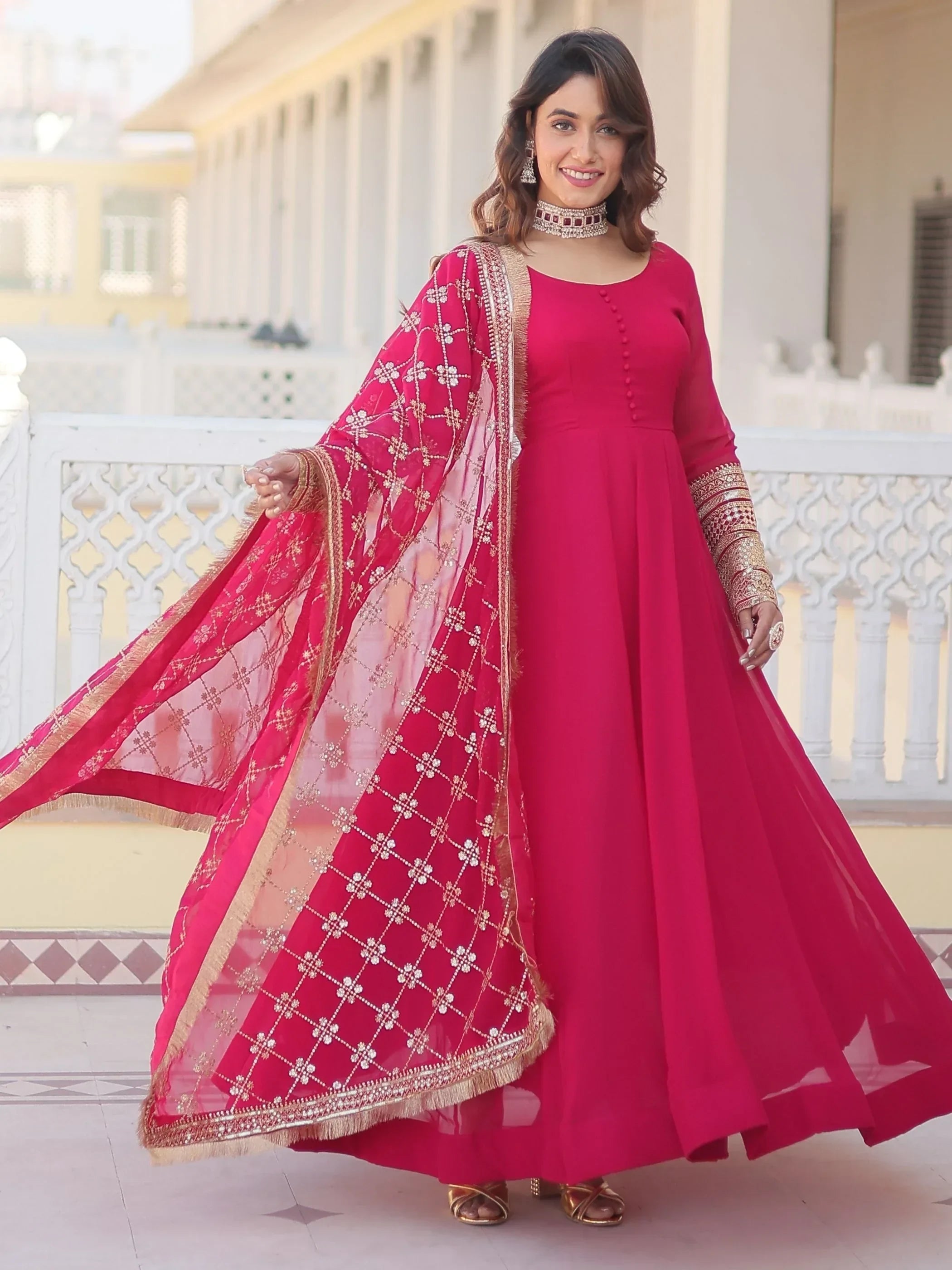 Woman in pink Anarkali suit with embroidered net dupatta and gold jewelry