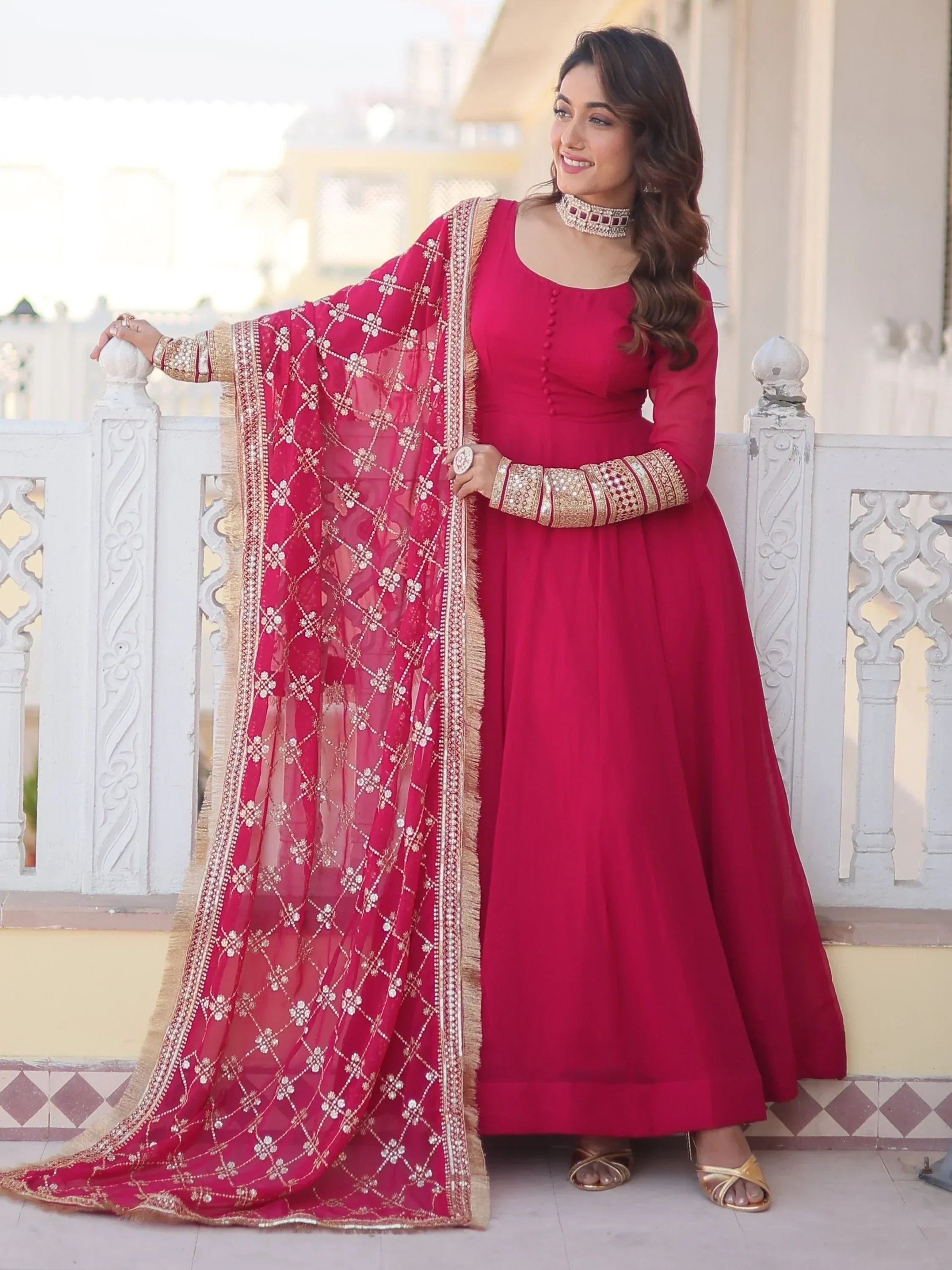 Woman in pink Anarkali suit with embroidered dupatta and traditional jewelry