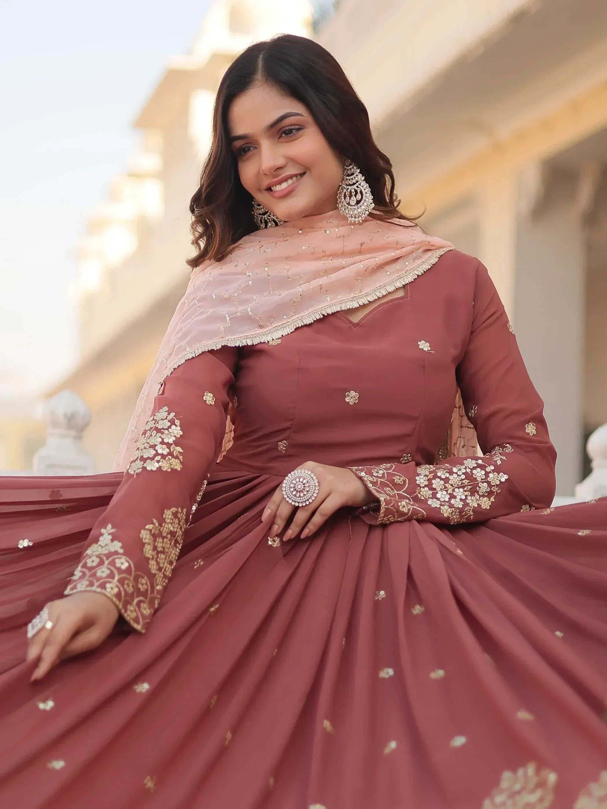 Woman in maroon embroidered lehenga choli with gold floral work and matching dupatta, ideal for Indian ethnic occasions