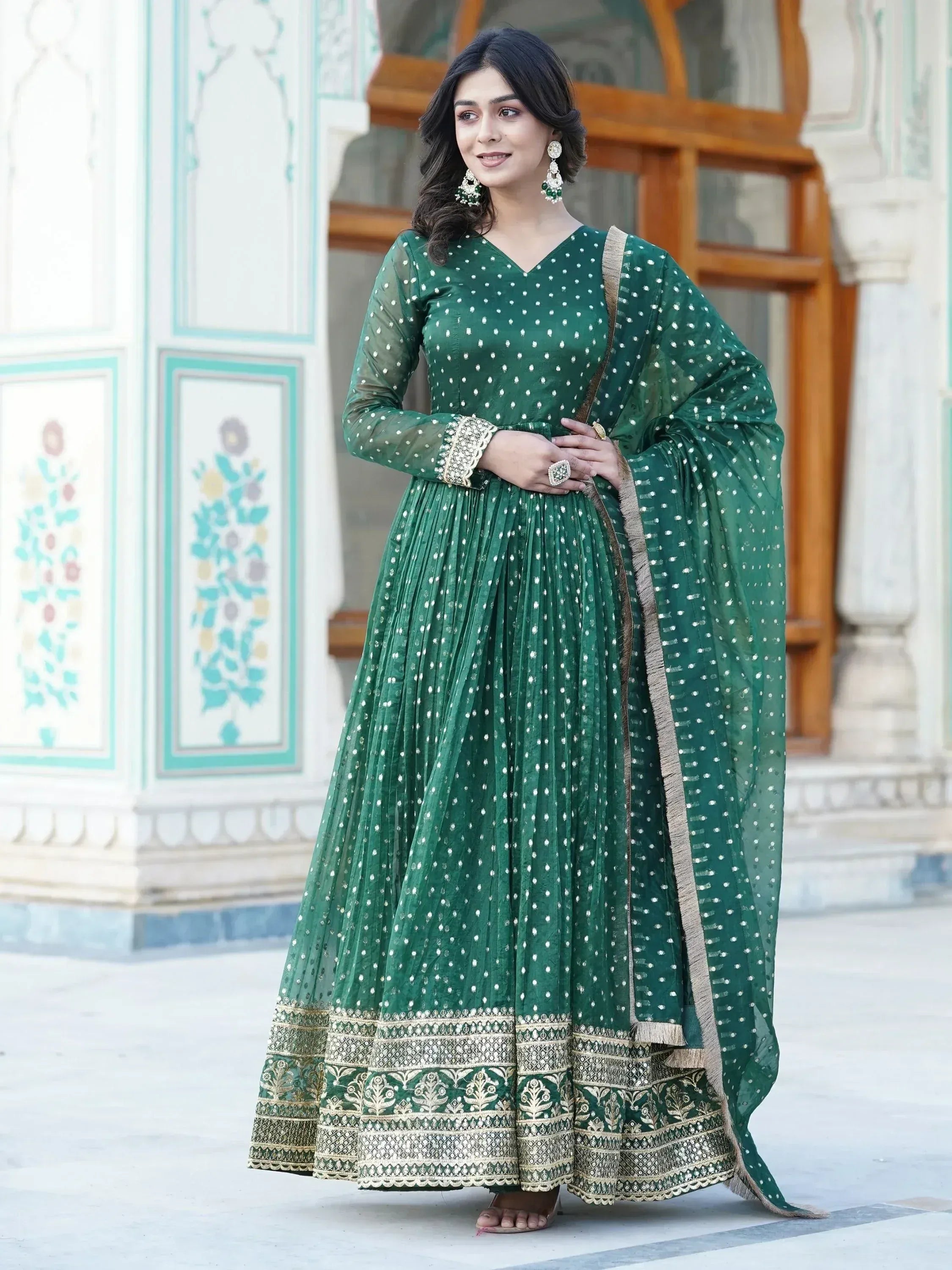 Emerald green ethnic anarkali with white polka dots and gold embroidery, perfect for Indian weddings or festive occasions.