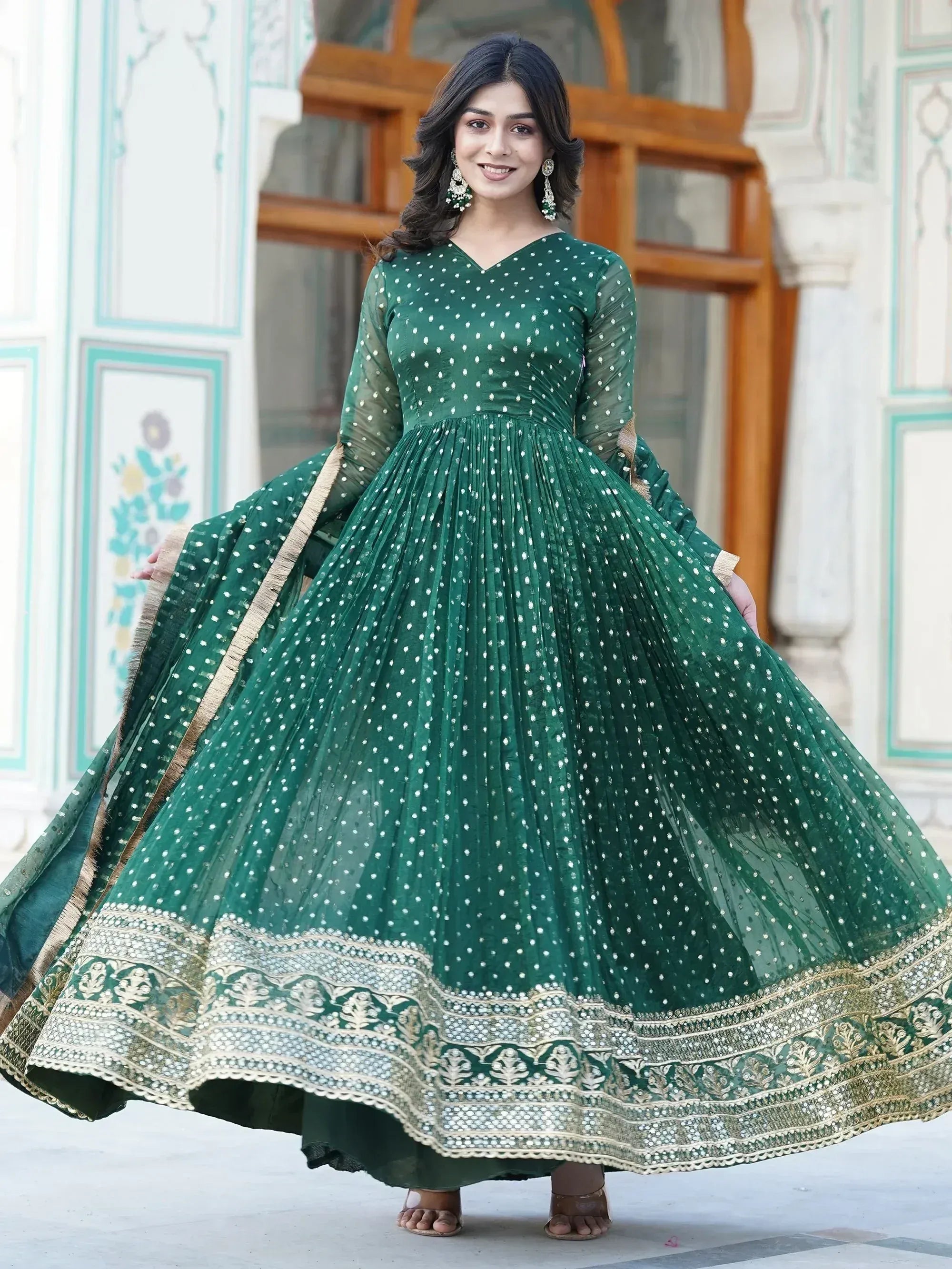 Emerald green ethnic gown with white polka dots and gold embroidery, perfect for Indian celebrations