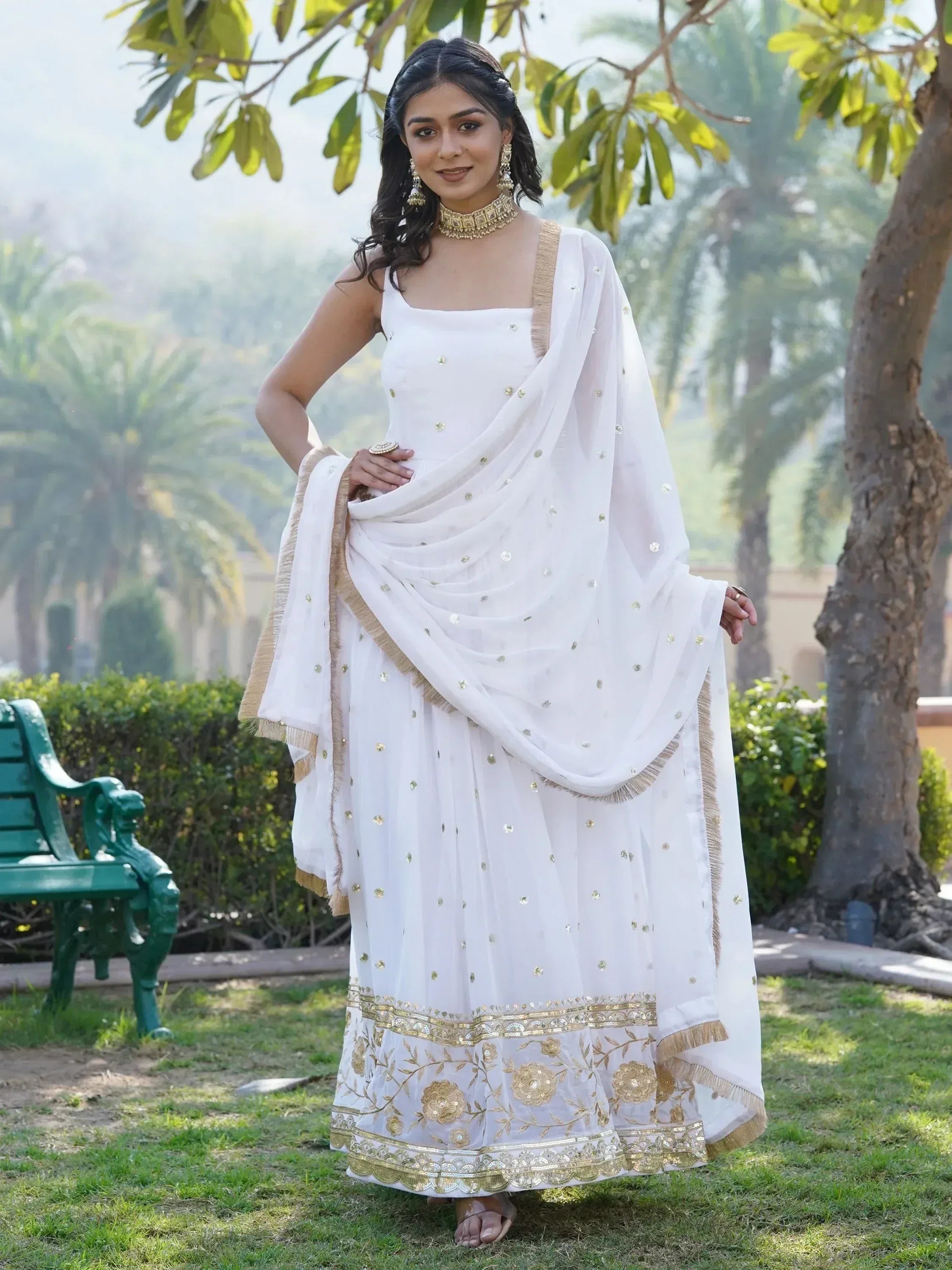 White ethnic gown with gold embroidery and dupatta, perfect for Indian weddings and festive occasions.