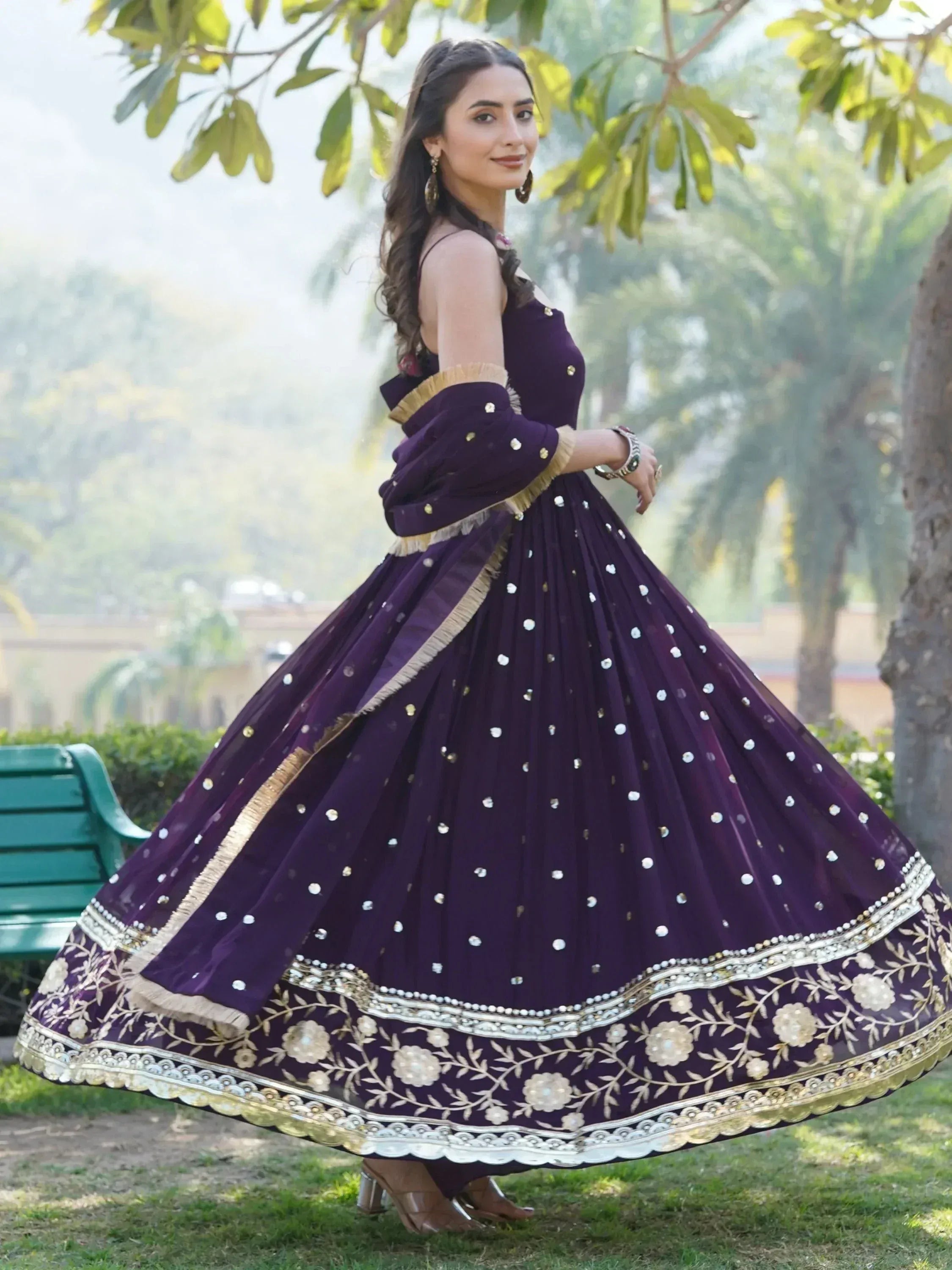 Woman in purple designer lehenga choli with gold embroidery, perfect for Indian ethnic wear occasions.