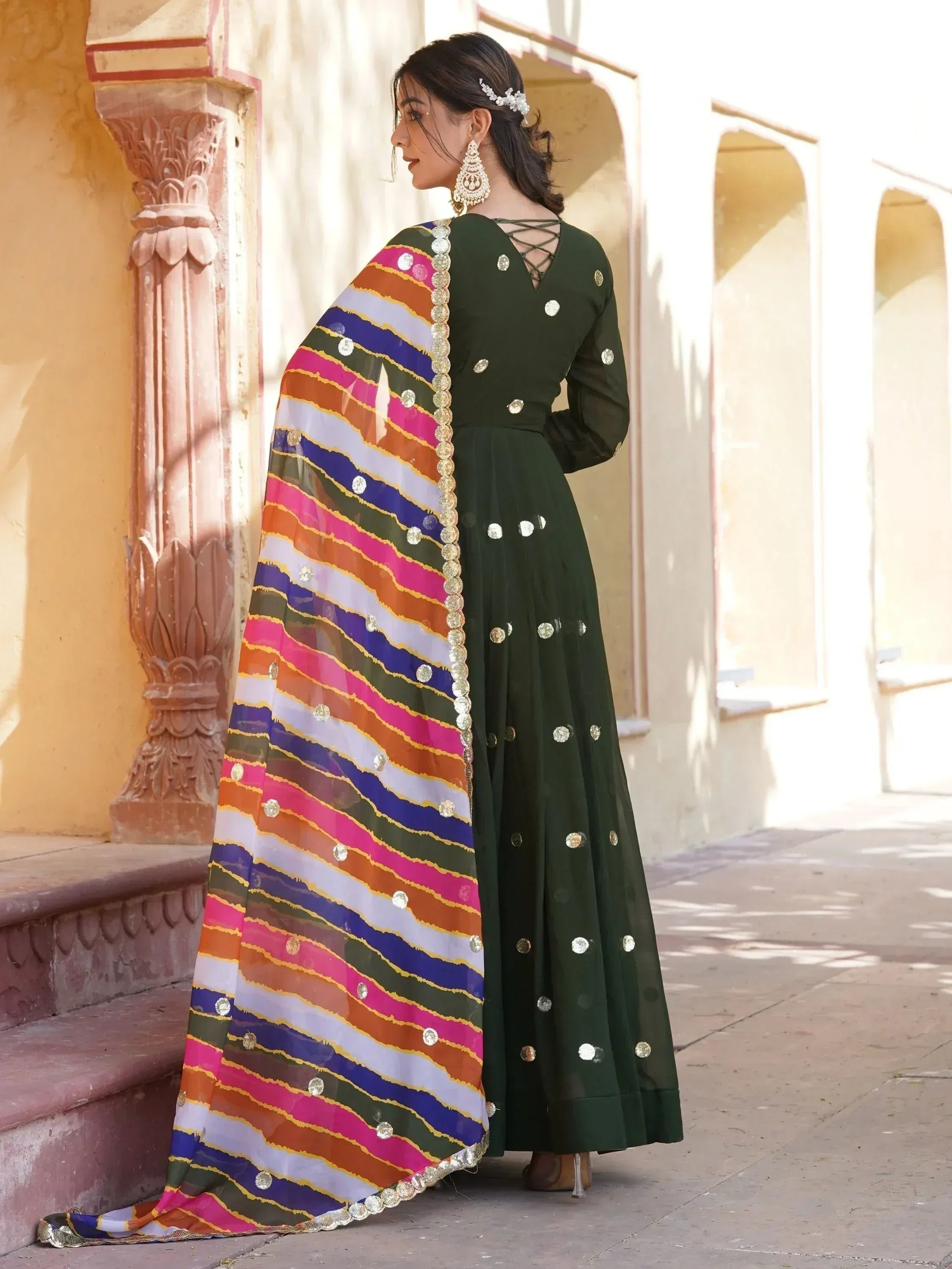 Green ethnic gown with colorful striped dupatta, perfect for Indian festive occasions and weddings.