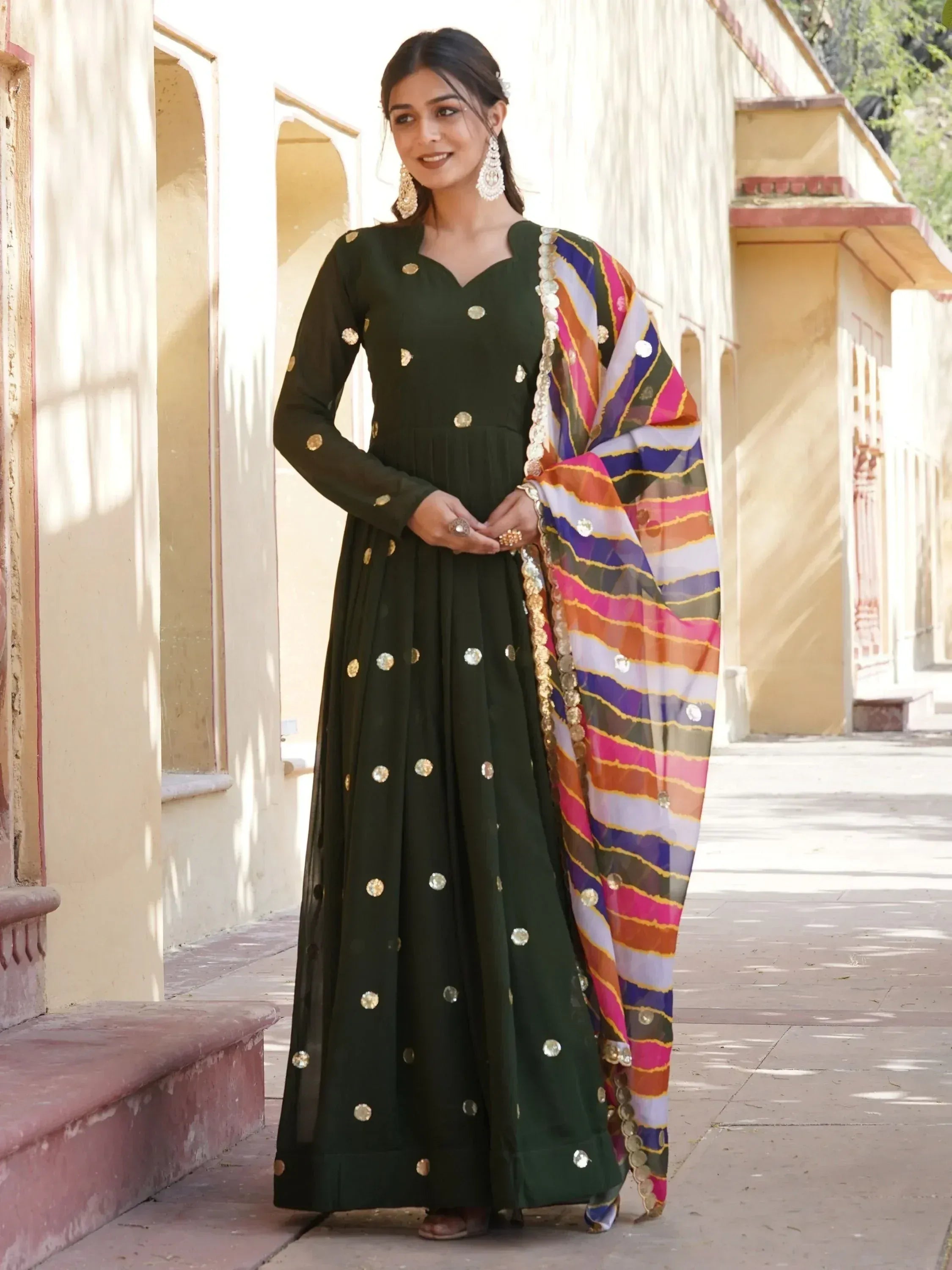 Green ethnic anarkali with gold mirror work and colorful striped dupatta, perfect for Indian festive occasions.