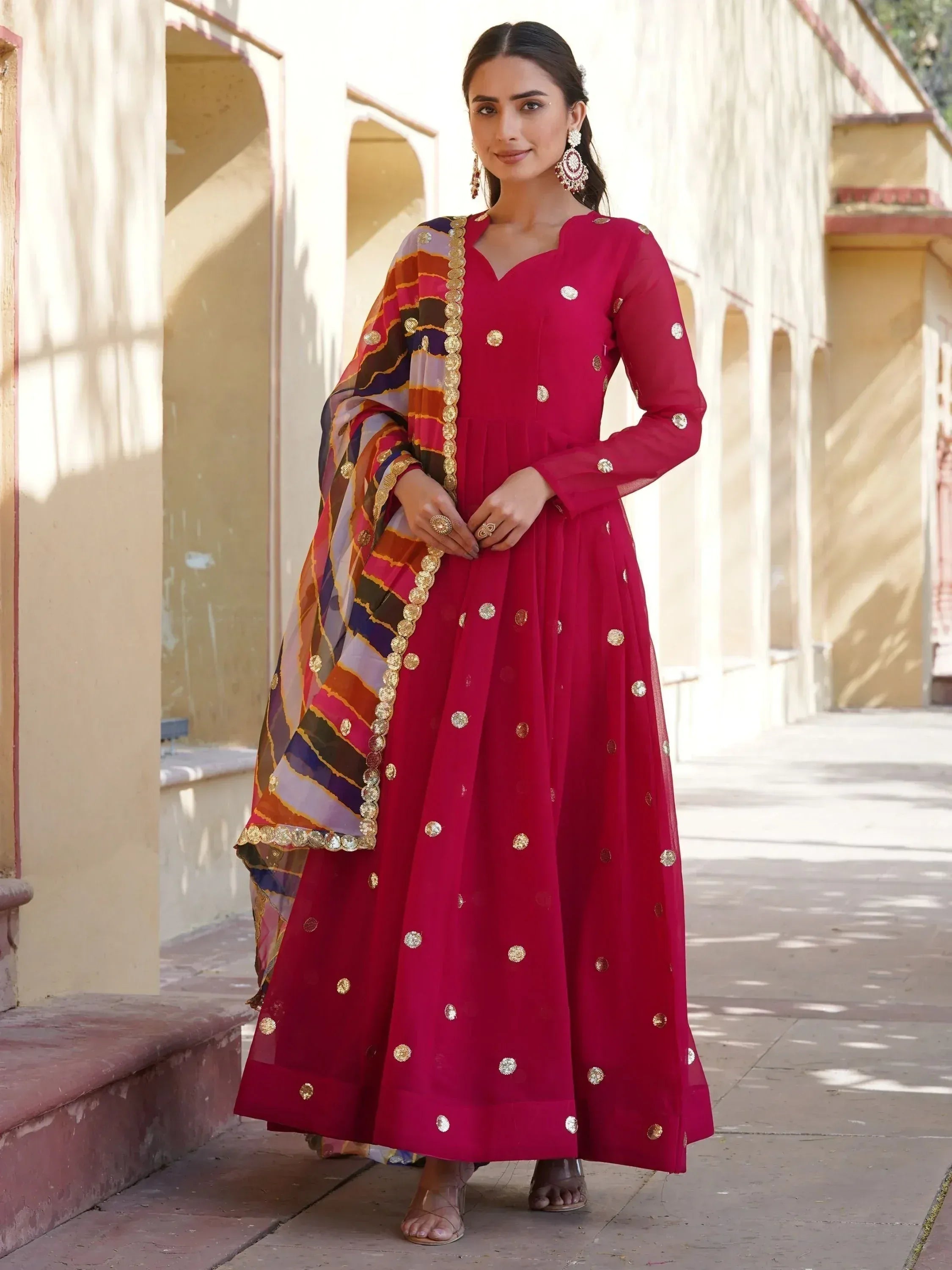 Woman in maroon ethnic anarkali with gold embellishments and colorful dupatta, perfect for Indian occasions