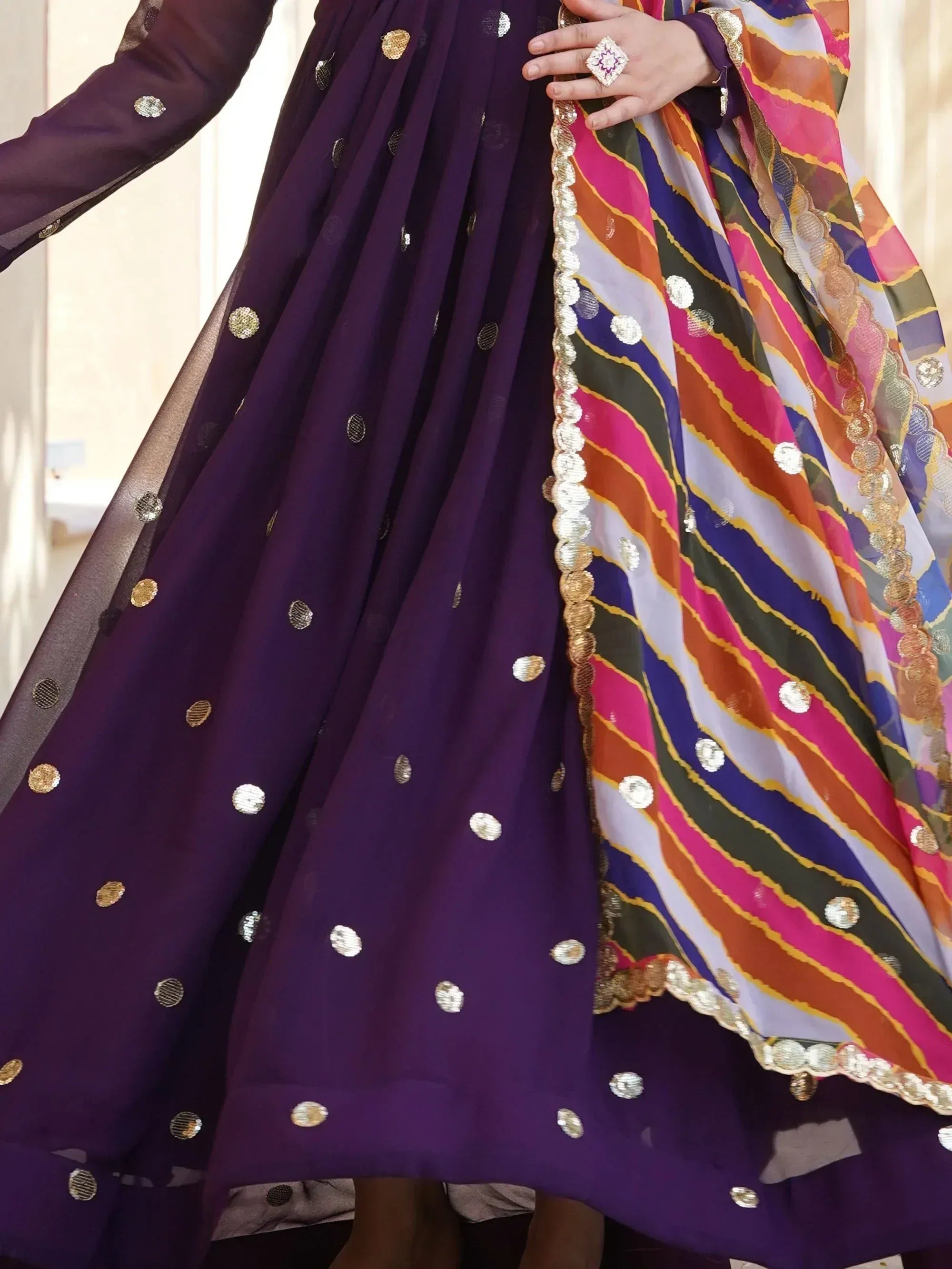 Purple ethnic gown with gold sequins and colorful striped dupatta, perfect for Indian celebrations