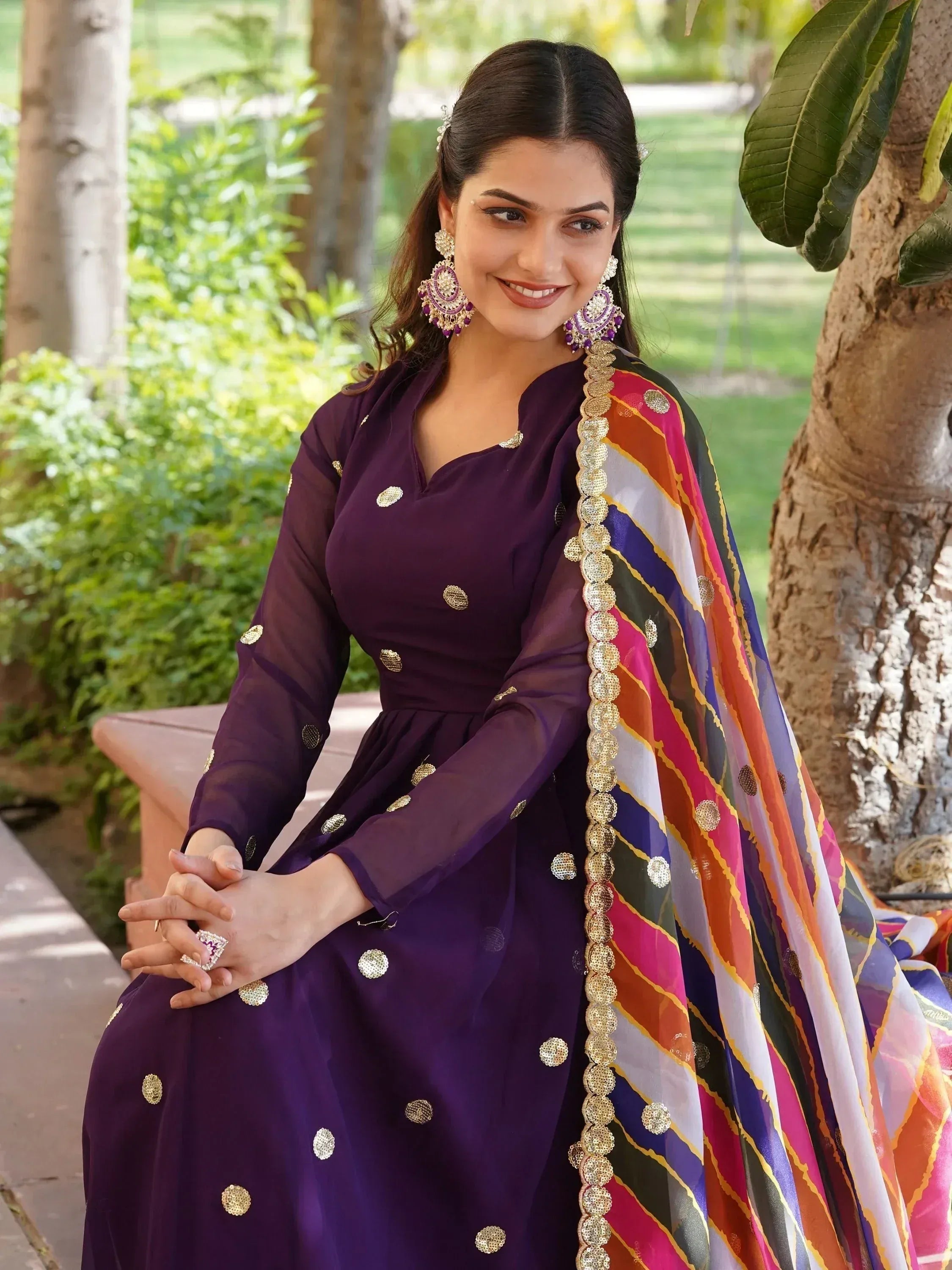 Purple ethnic gown with gold embellishments and colorful dupatta, perfect for Indian festive occasions