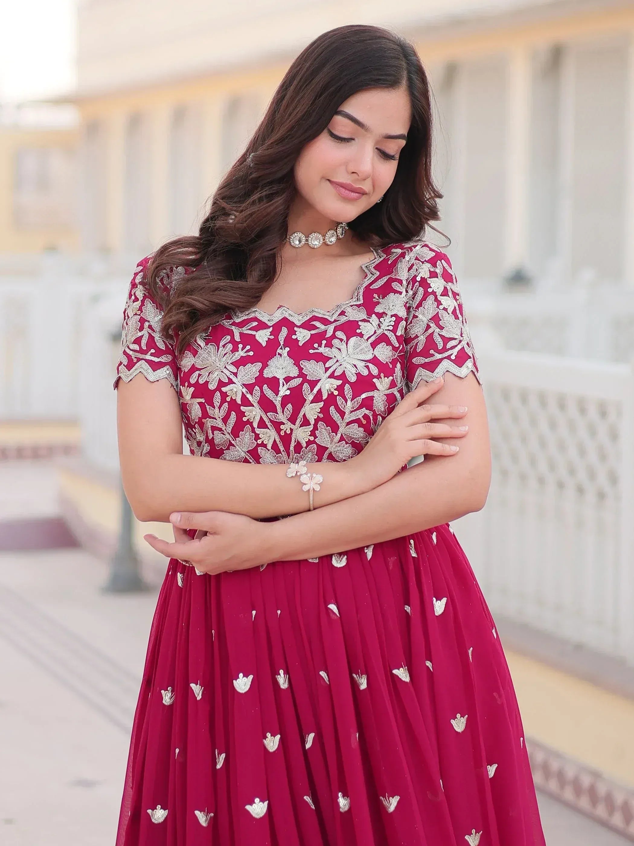 Woman in maroon ethnic gown with silver floral embroidery, perfect for Indian occasions