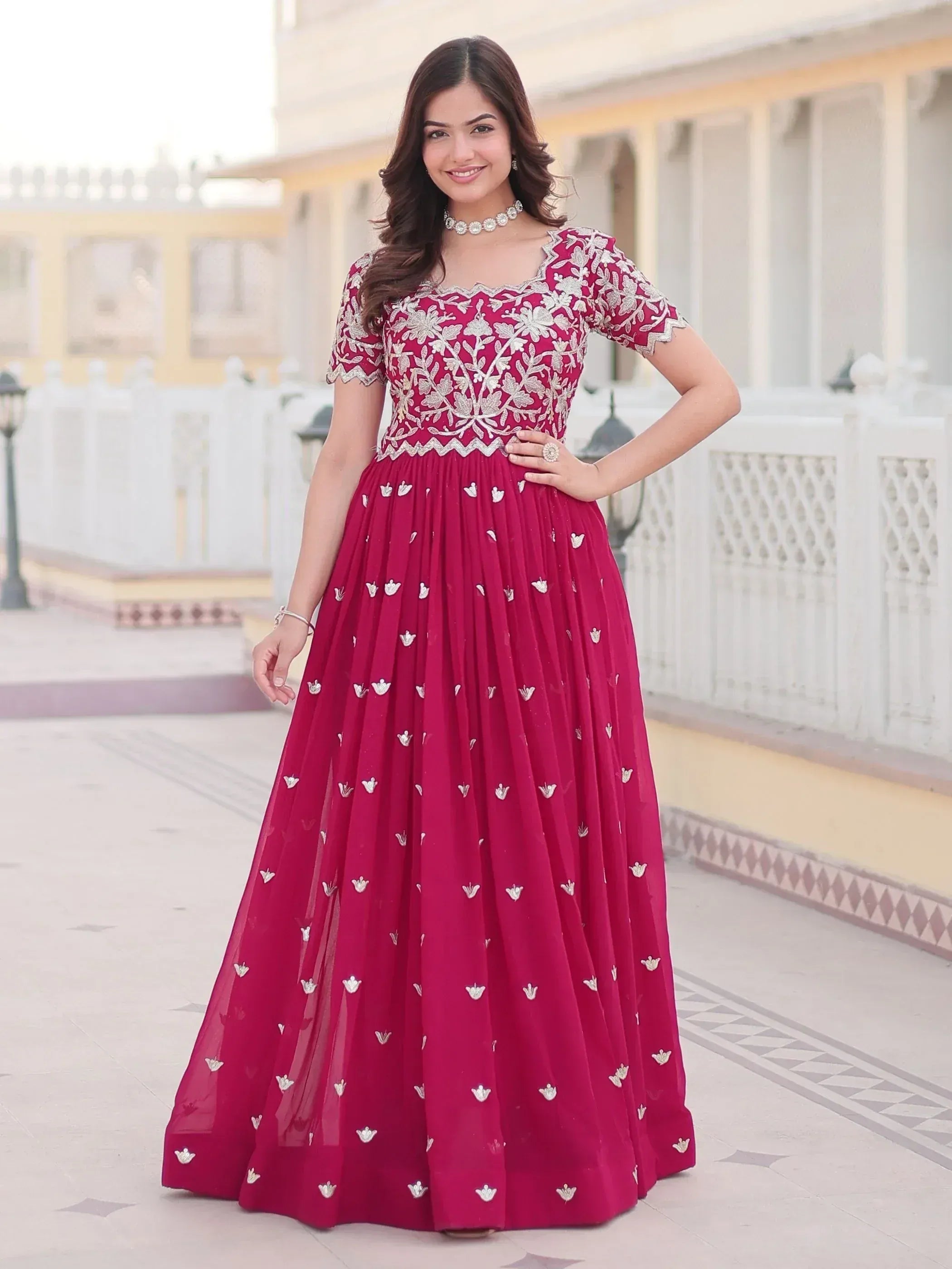 Elegant maroon ethnic gown with silver floral embroidery, perfect for Indian weddings and festive occasions.