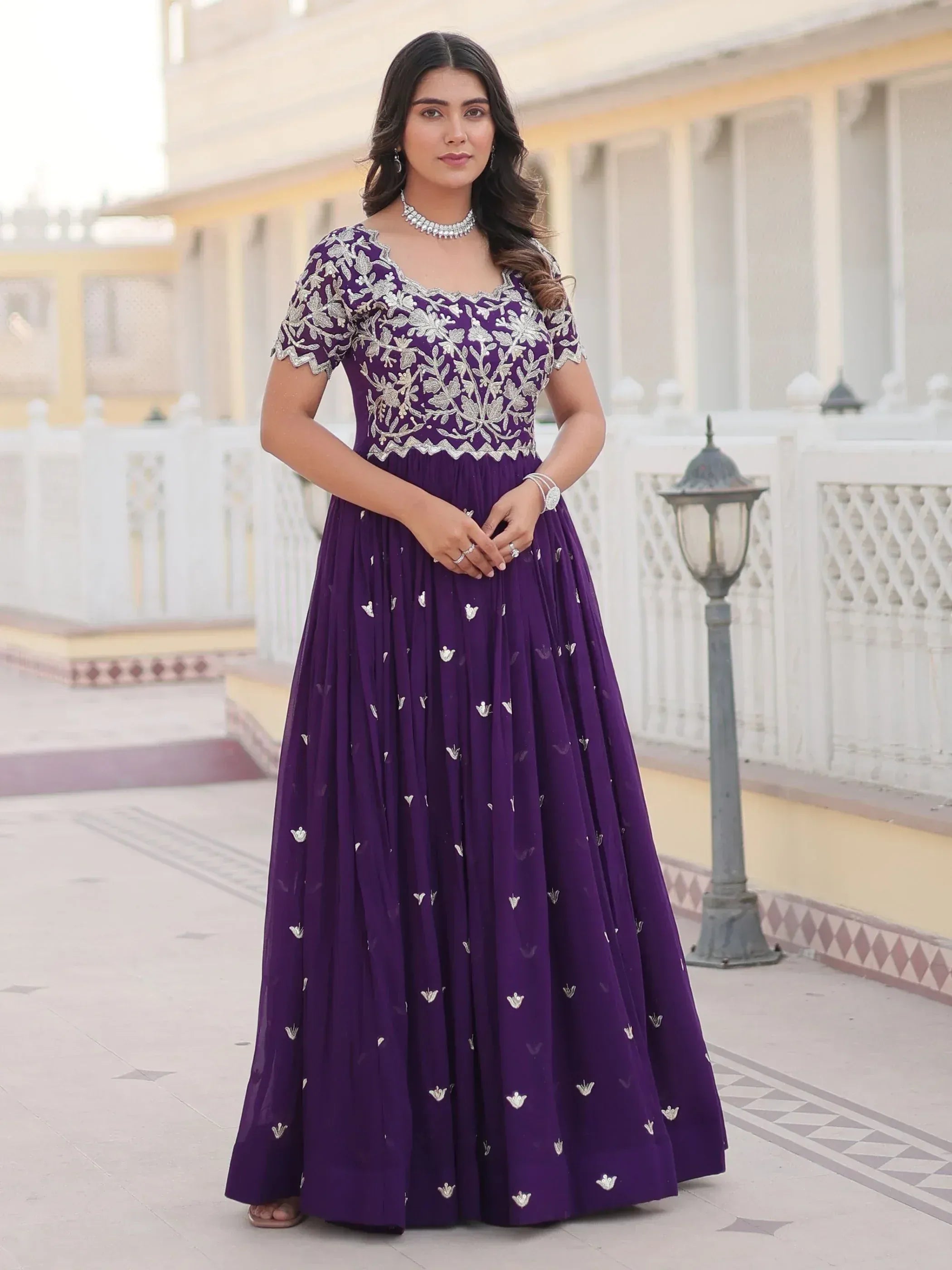 Purple embroidered ethnic gown with floral detailing, perfect for Indian weddings and festive occasions.
