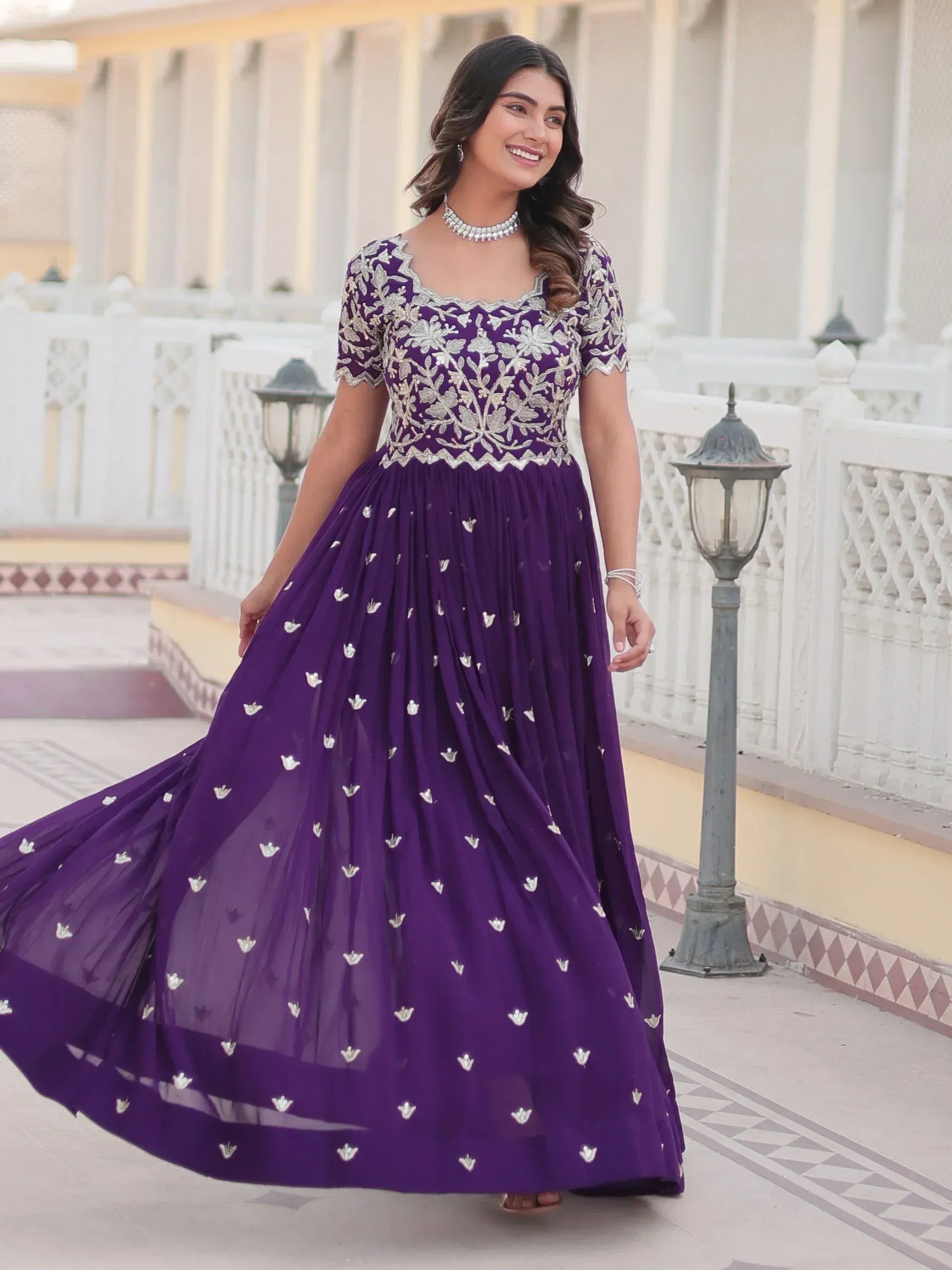 Purple embroidered ethnic gown with floral detailing, perfect for Indian weddings and festive occasions.