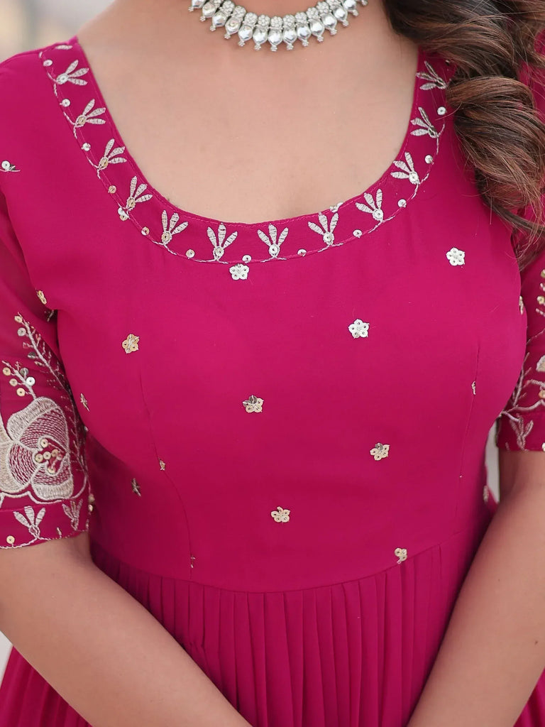 Pink ethnic gown with floral embroidery and sequin detailing, paired with statement necklace