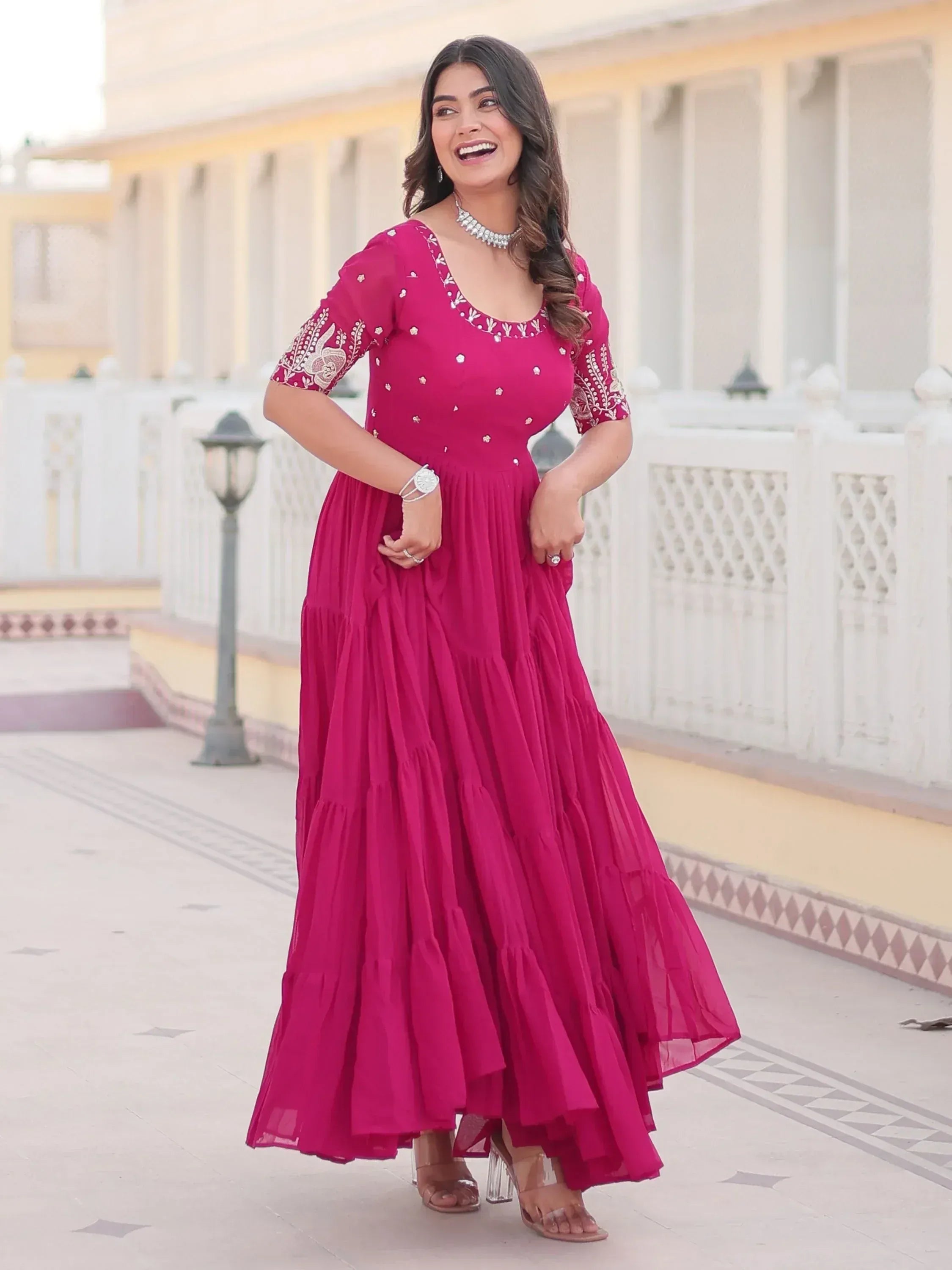 Woman in vibrant pink ethnic gown with embroidery, perfect for Indian occasions and festive wear