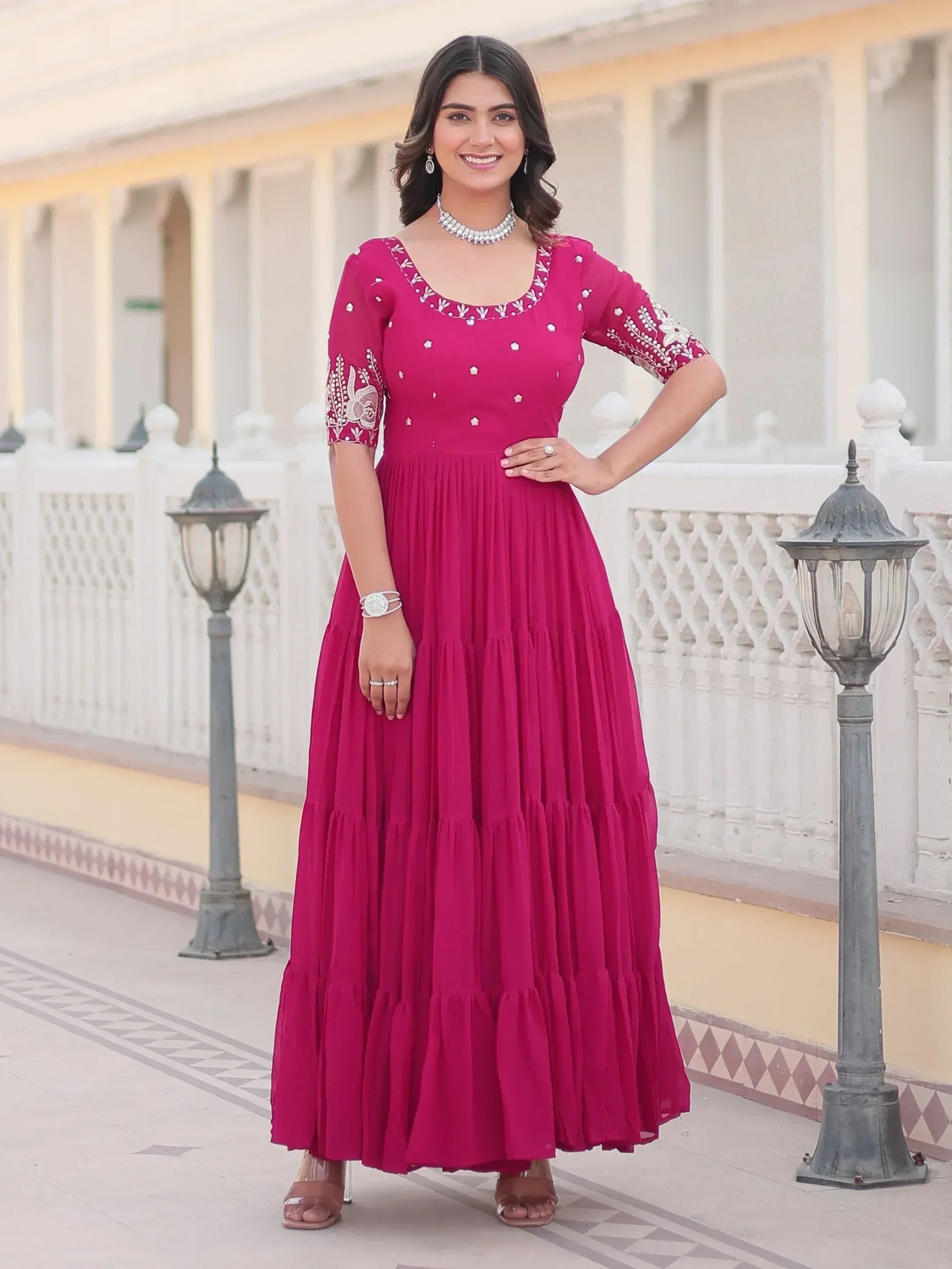 Woman in magenta ethnic gown with embroidery, perfect for Indian occasions and festive wear.