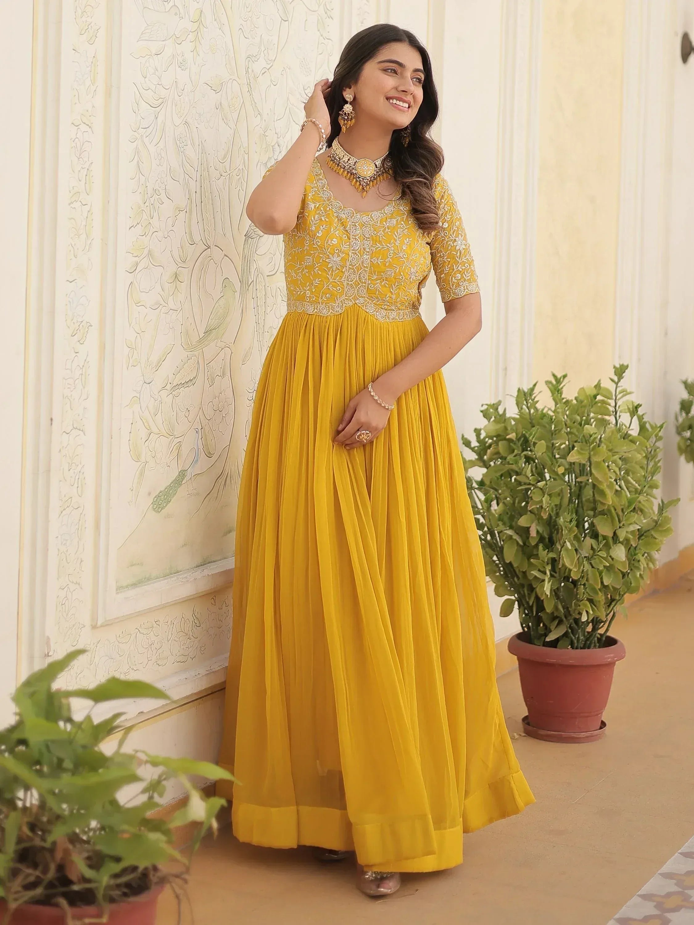 Yellow embroidered ethnic gown with pleated skirt, perfect for Indian occasions and festive wear.
