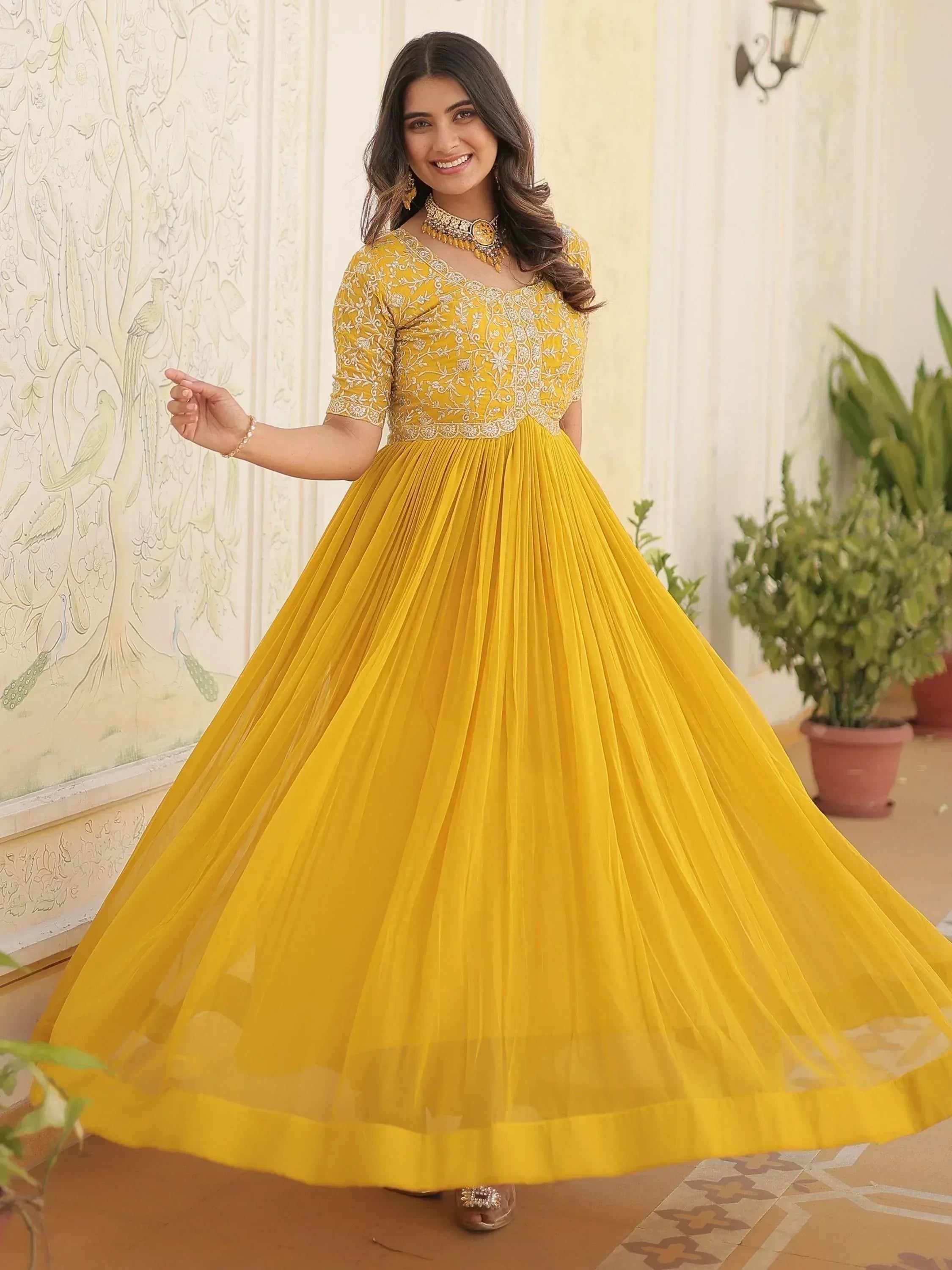 Yellow embroidered ethnic gown with pleated skirt, perfect for Indian festive occasions and weddings