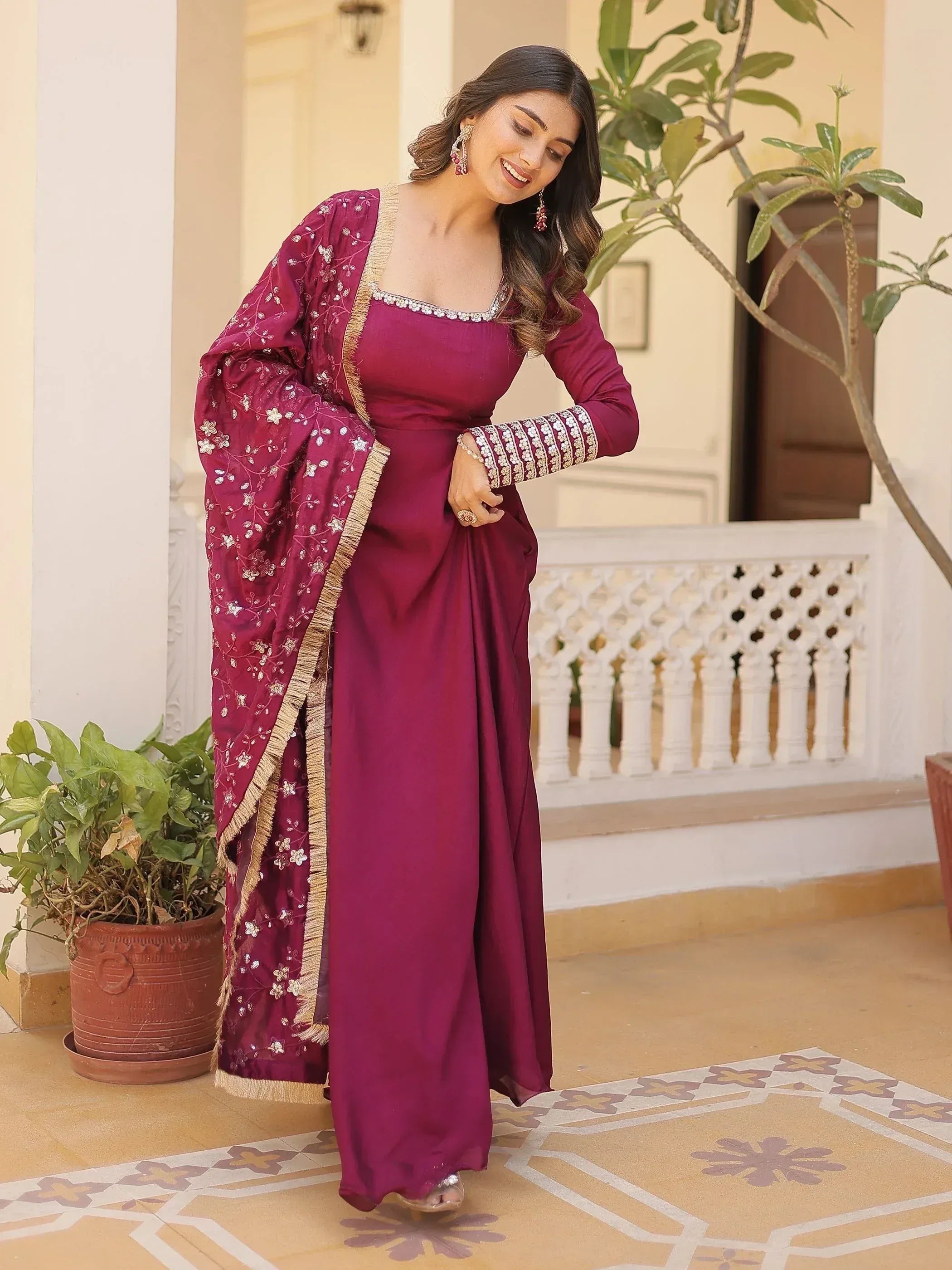 Elegant maroon ethnic gown with floral embroidery and gold trim, perfect for Indian occasions