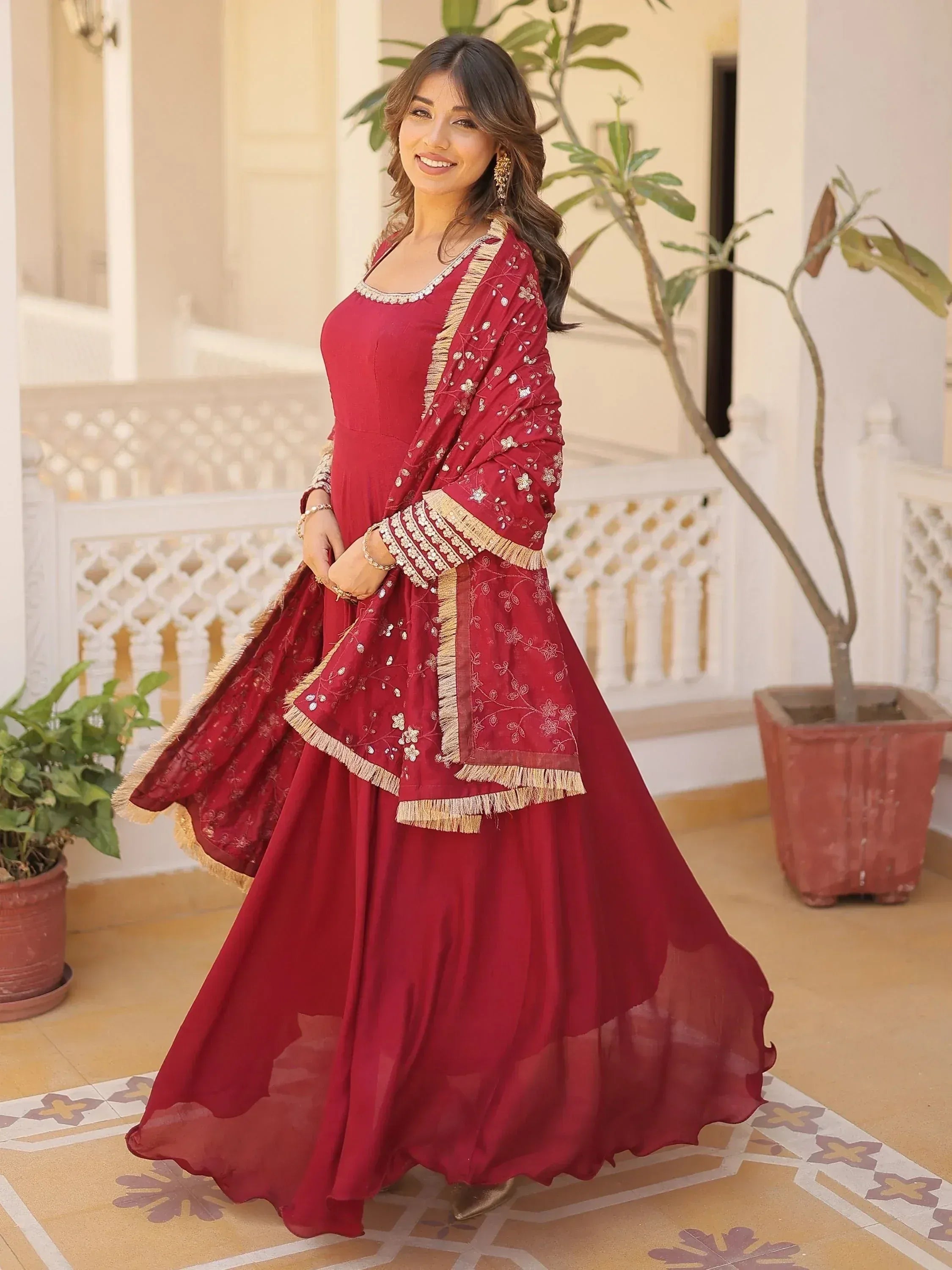 Red embroidered ethnic gown with gold fringe, perfect for Indian weddings and festive occasions