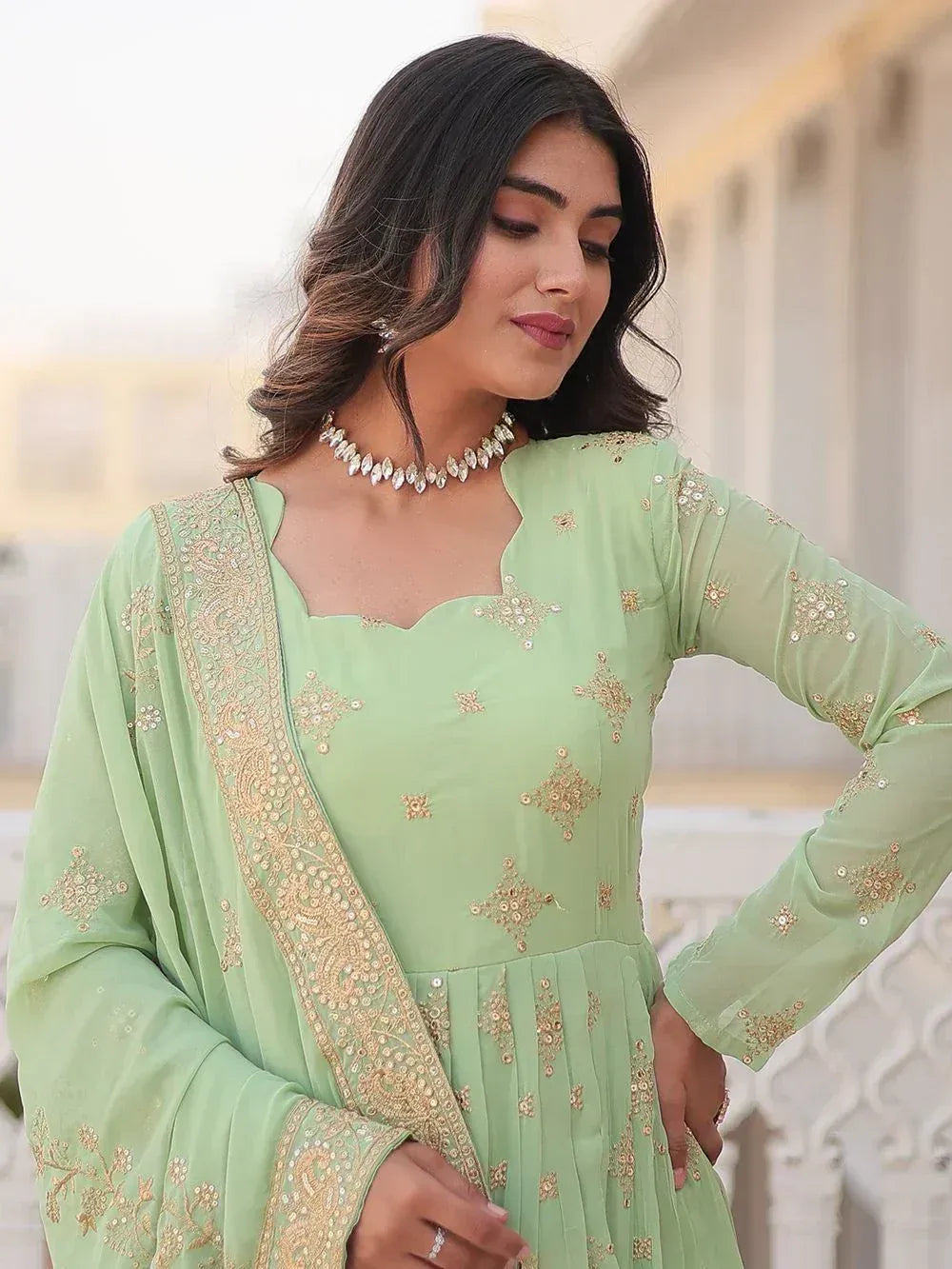 Mint green embroidered ethnic gown with gold detailing, perfect for Indian festive occasions