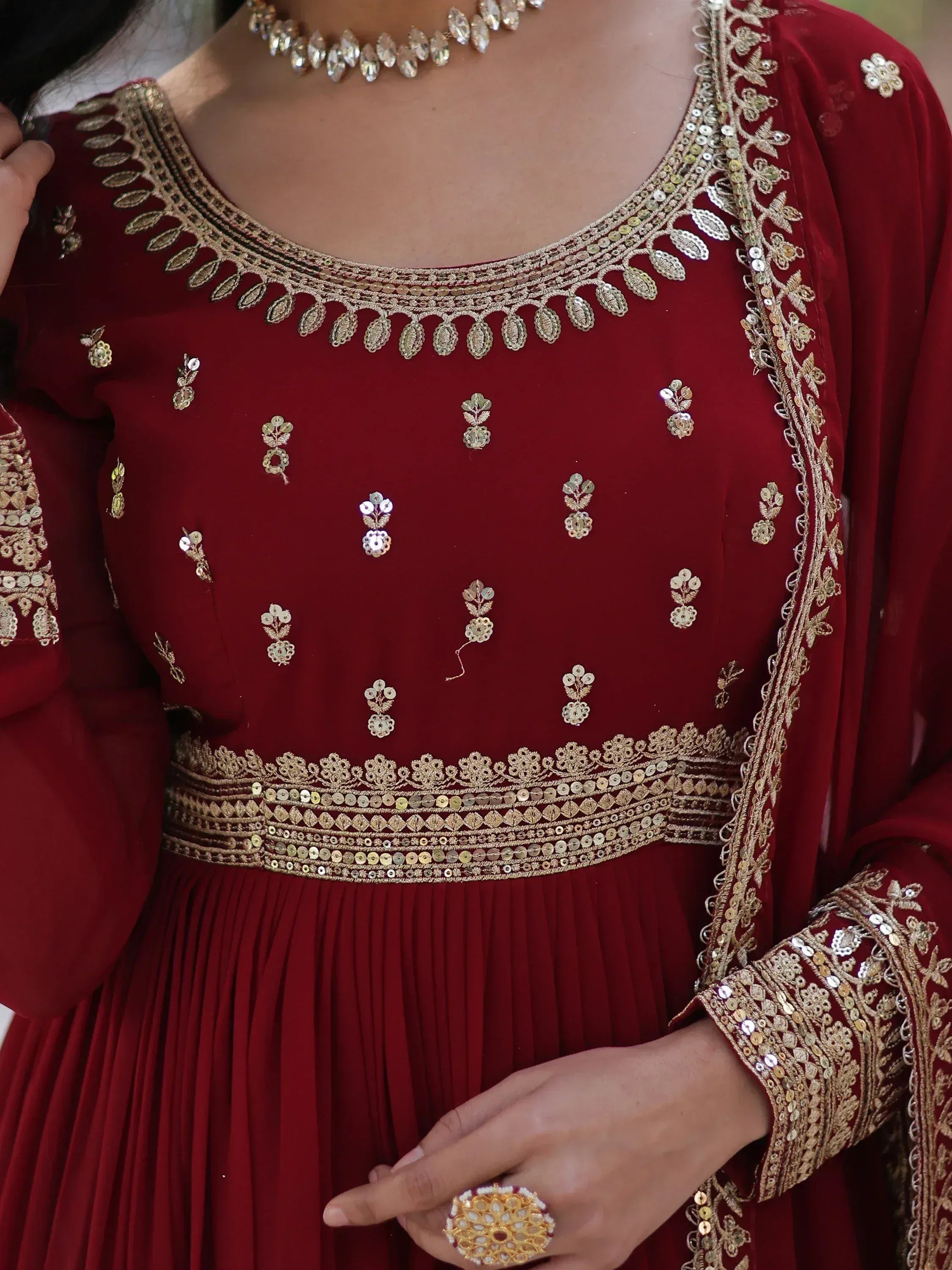 Red ethnic gown with gold embroidery and sequins, perfect for Indian weddings and festive occasions.