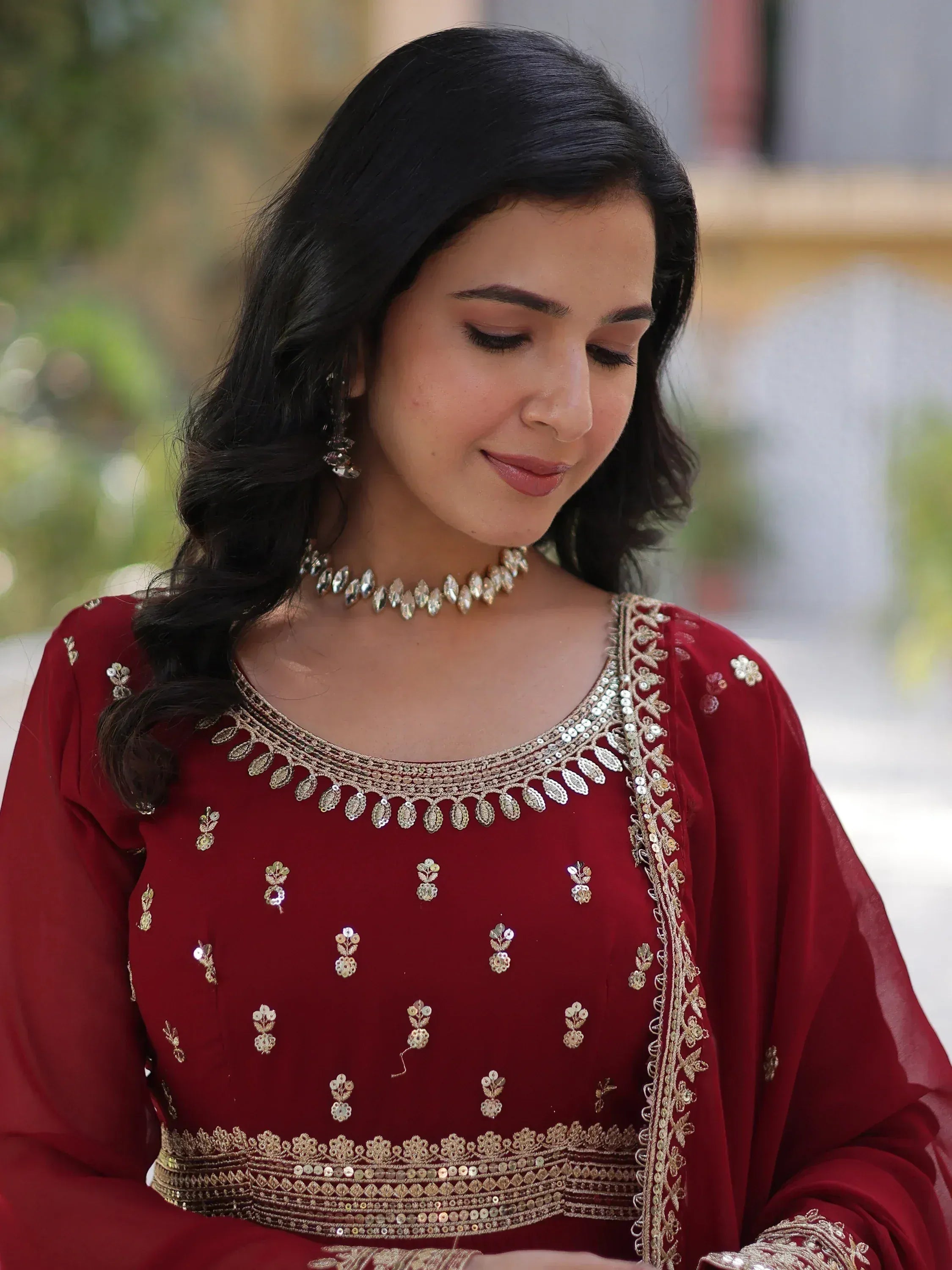 Woman in maroon ethnic wear with gold embroidery, perfect for Indian festive occasions and weddings.
