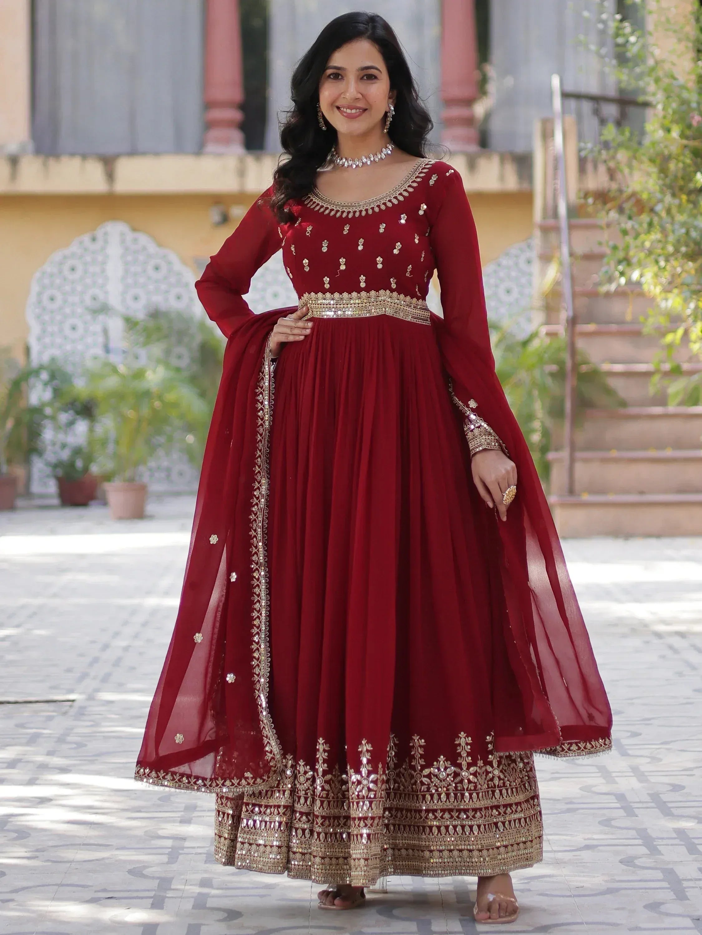 Elegant maroon ethnic gown with gold embroidery, perfect for Indian weddings and festive occasions.