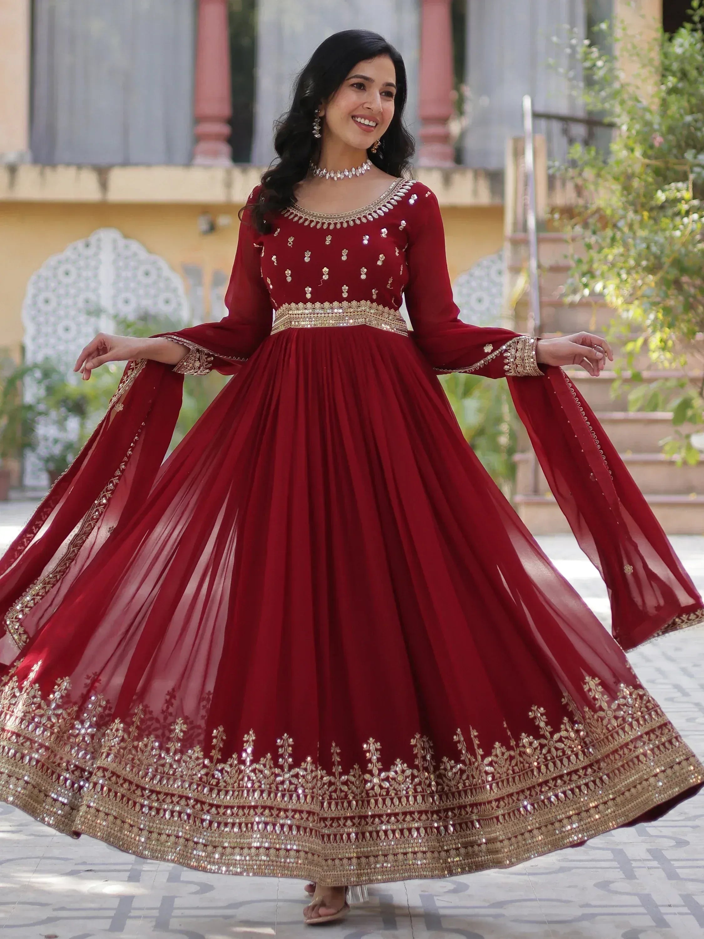 Woman in maroon ethnic gown with gold embroidery, perfect for Indian weddings and festive occasions