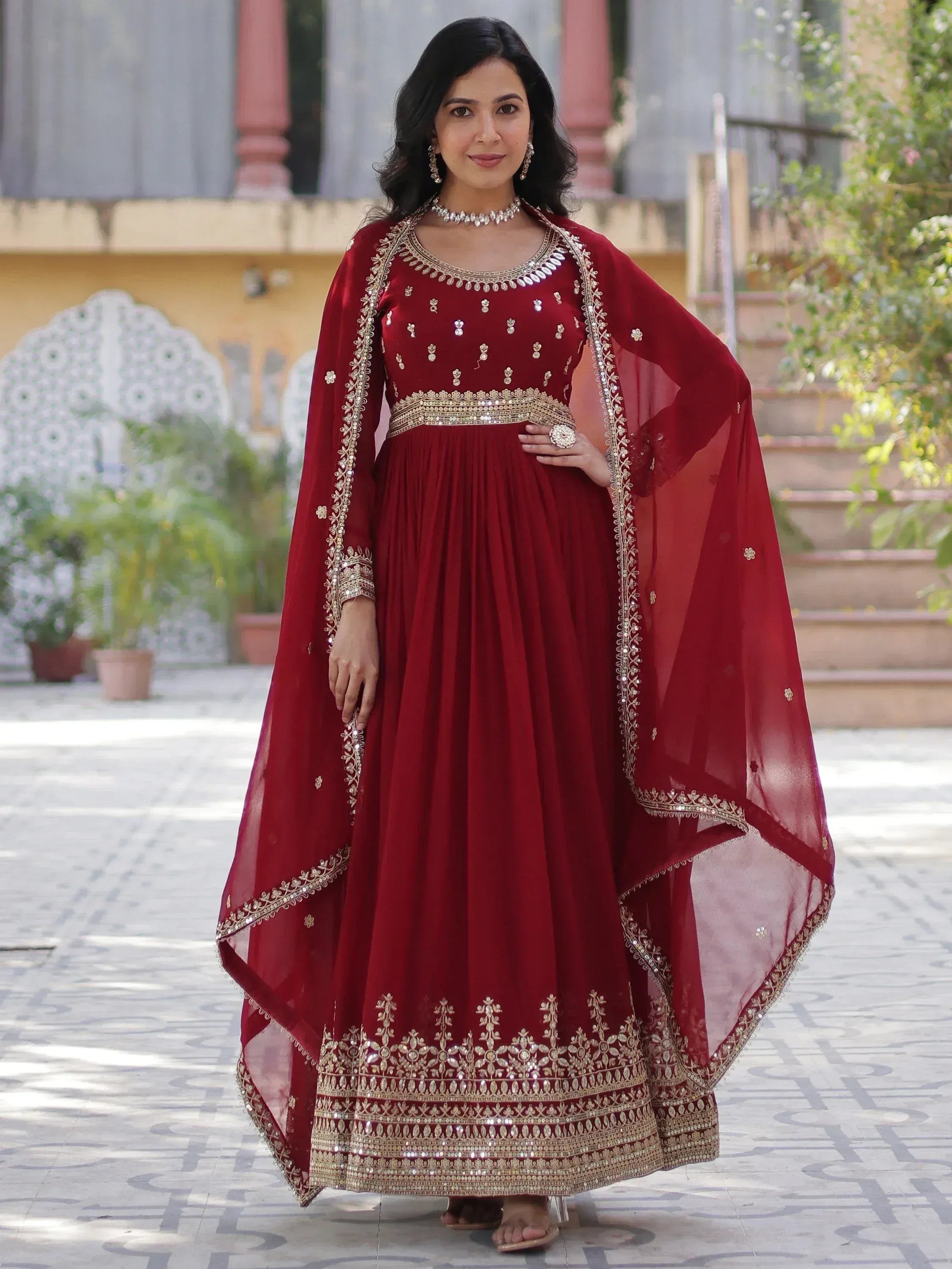 Elegant maroon ethnic gown with gold embroidery, perfect for Indian weddings and festive occasions.
